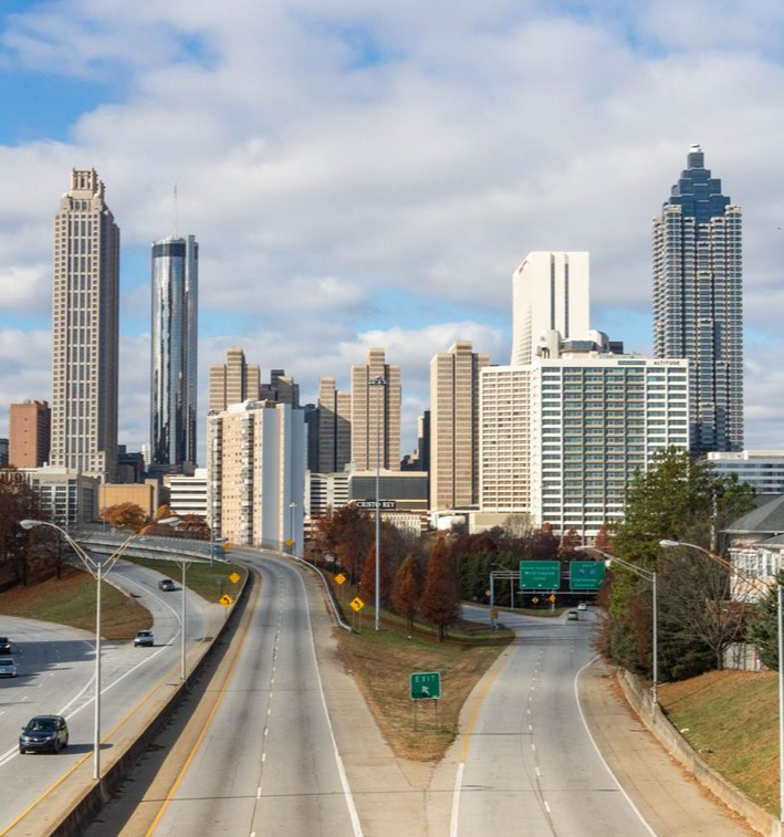 Downtown skyline beyond a divided highway under a cloudy sky