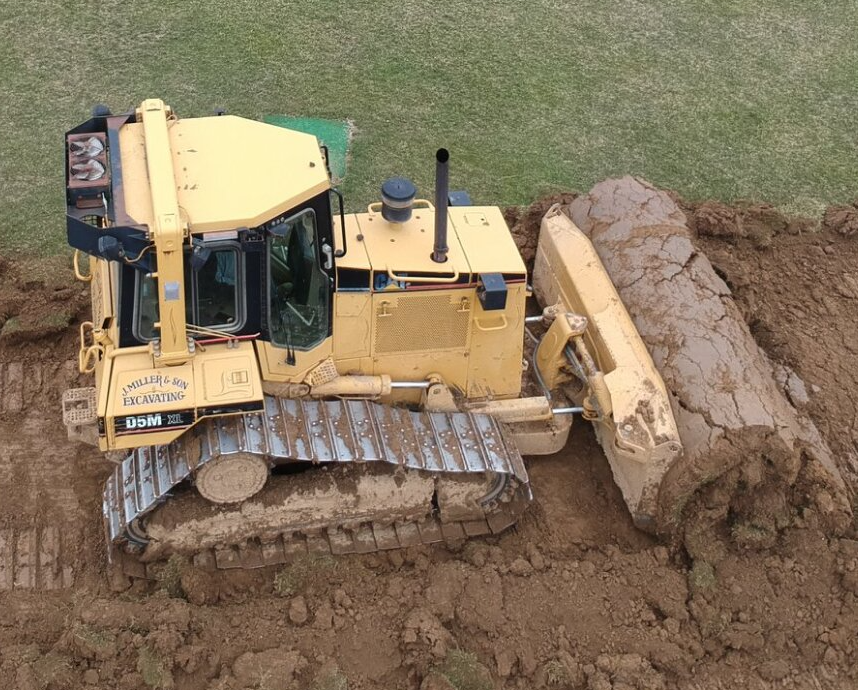 Yellow bulldozer pushing dirt.
