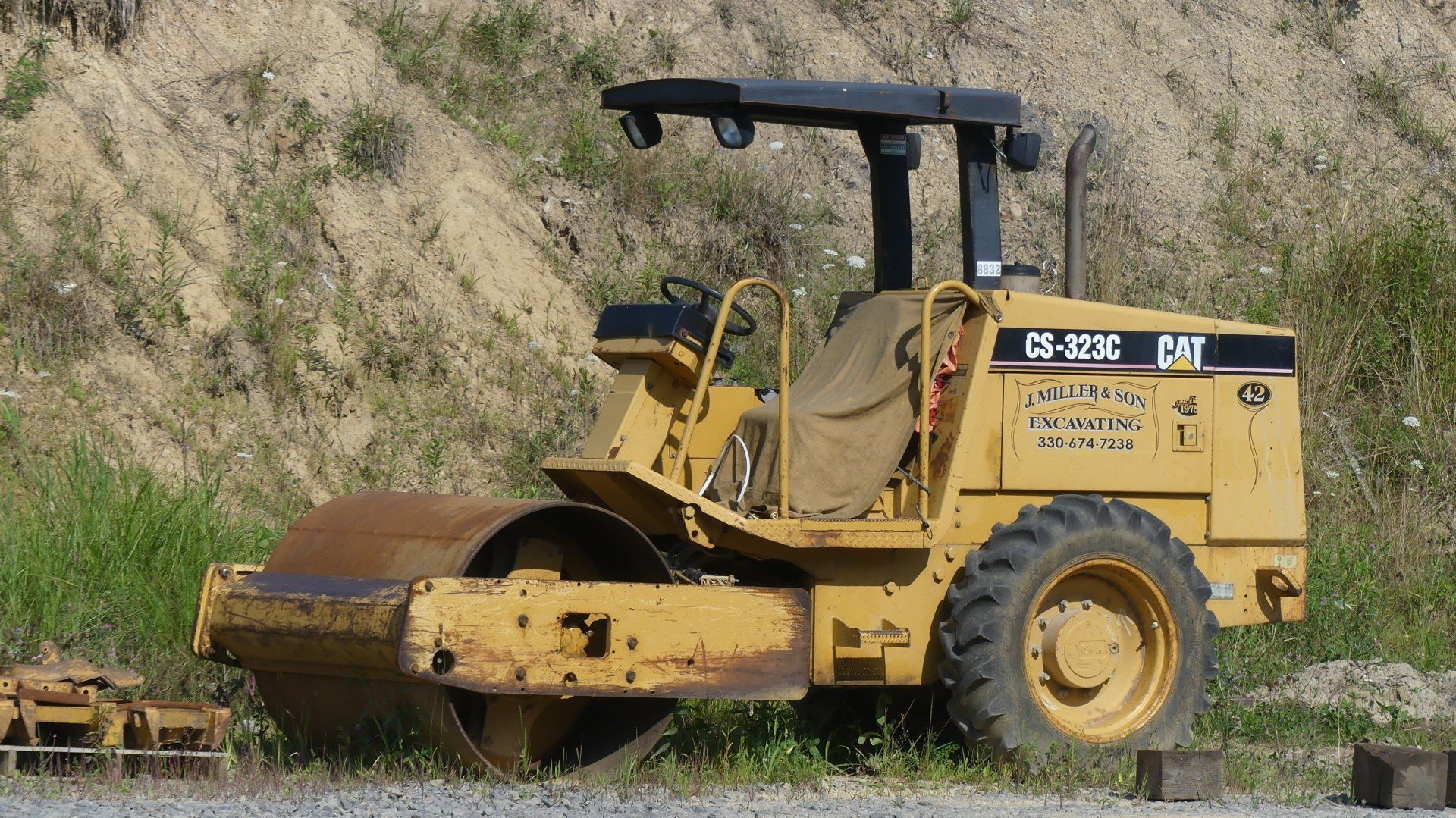 Yellow Caterpillar C35P compact vibratory soil compactor on a construction site.