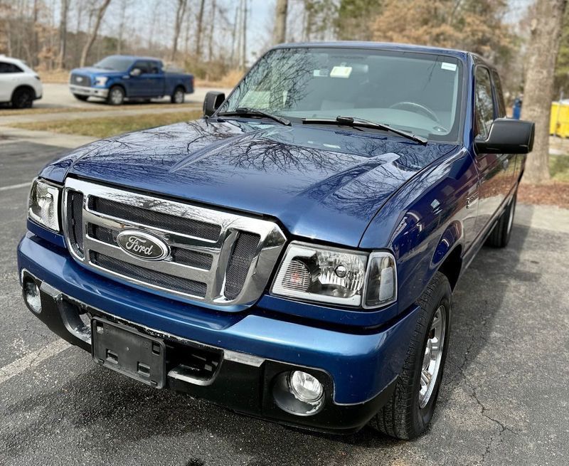 A blue Ford Ranger pickup truck parked in an outdoor lot on a sunny day.