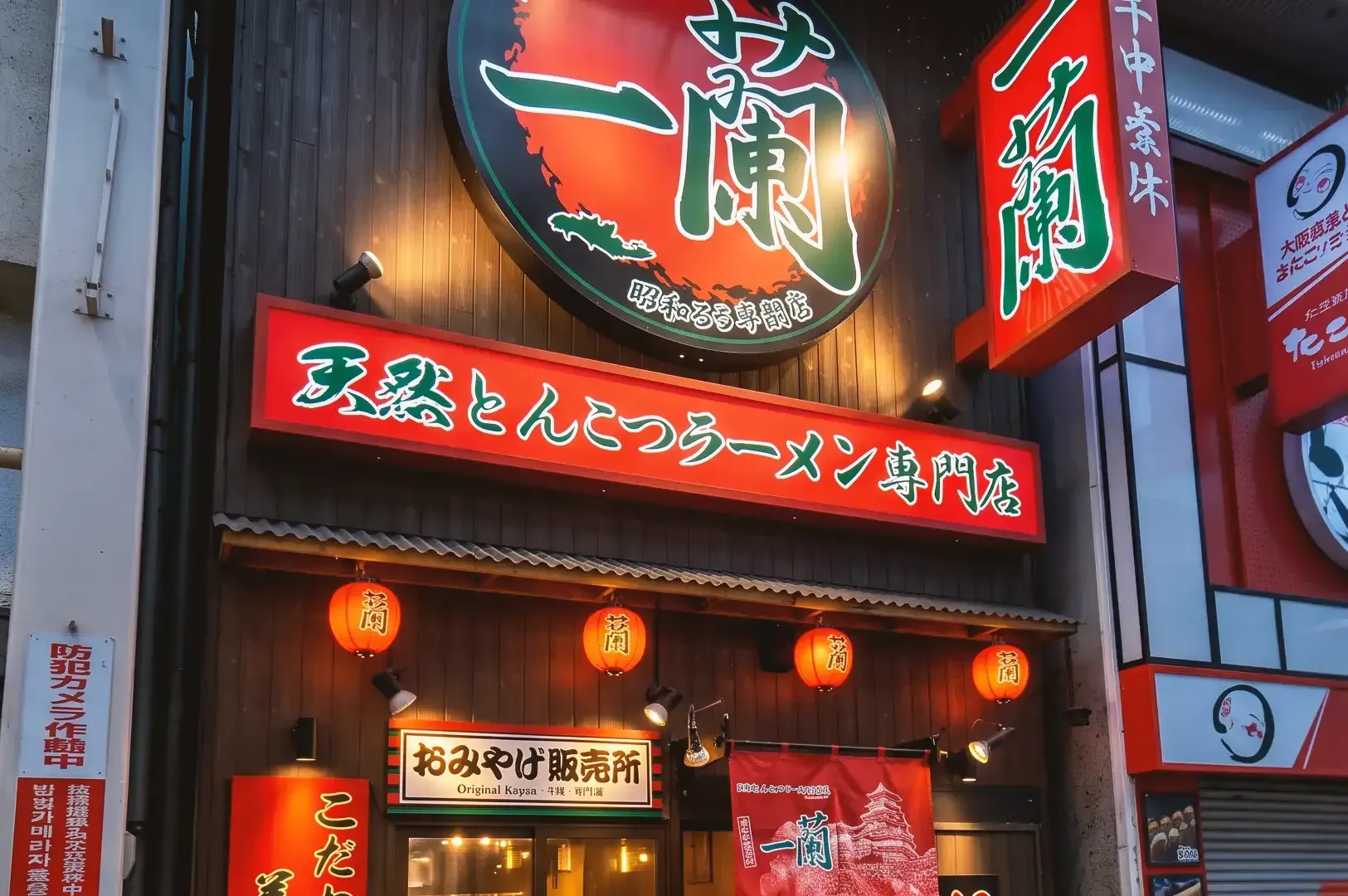 Storefront of Ichiran Ramen Dotonbori with displayed red signages with green japanese writings