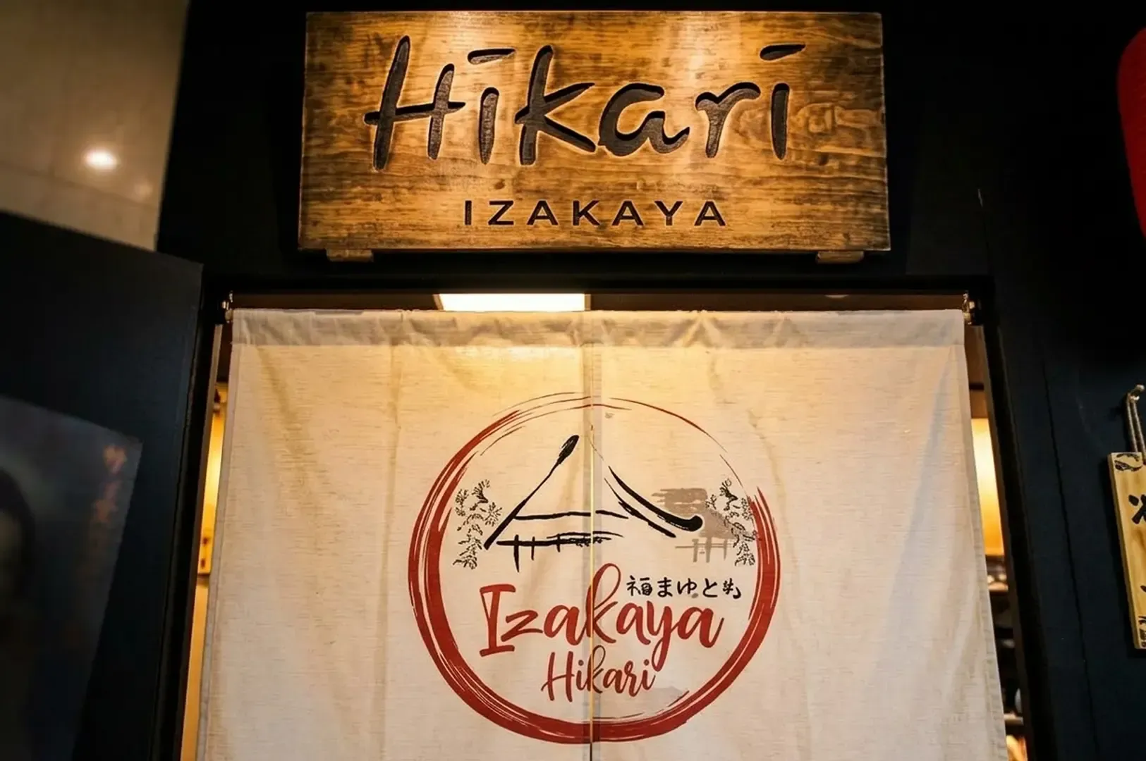 Hikari Izakaya wooden sign and entrance curtain