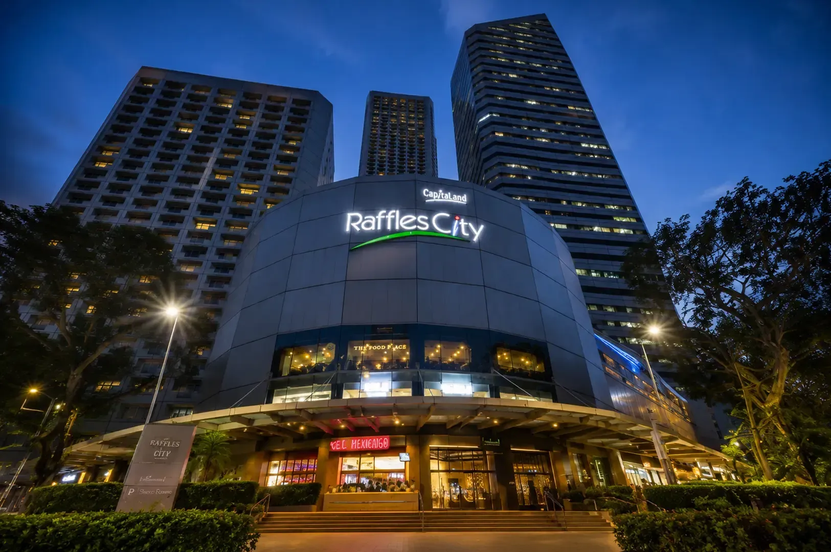 Raffles City shopping mall exterior at dusk with illuminated signage, modern architecture, and surrounding high-rise buildings in Singapore