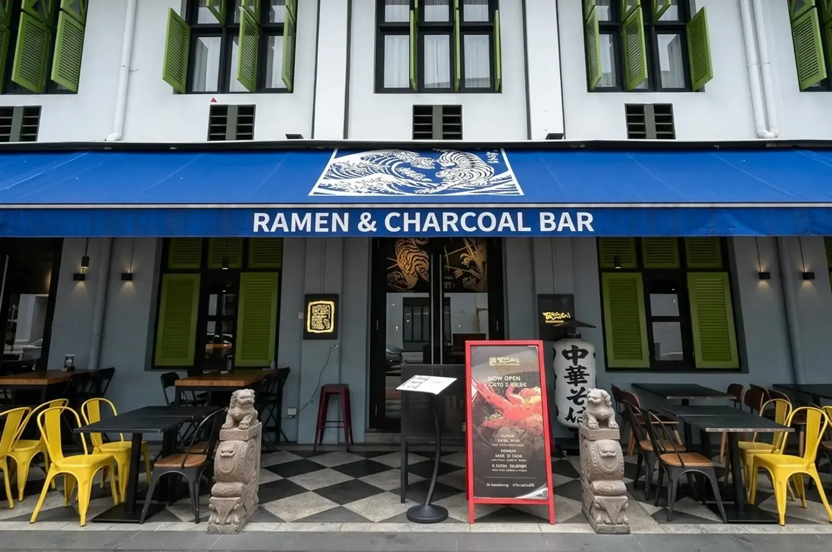 Torasho Ramen & Charcoal Bar storefront with blue awning, yellow outdoor chairs, and stone guardian statues at entrance
