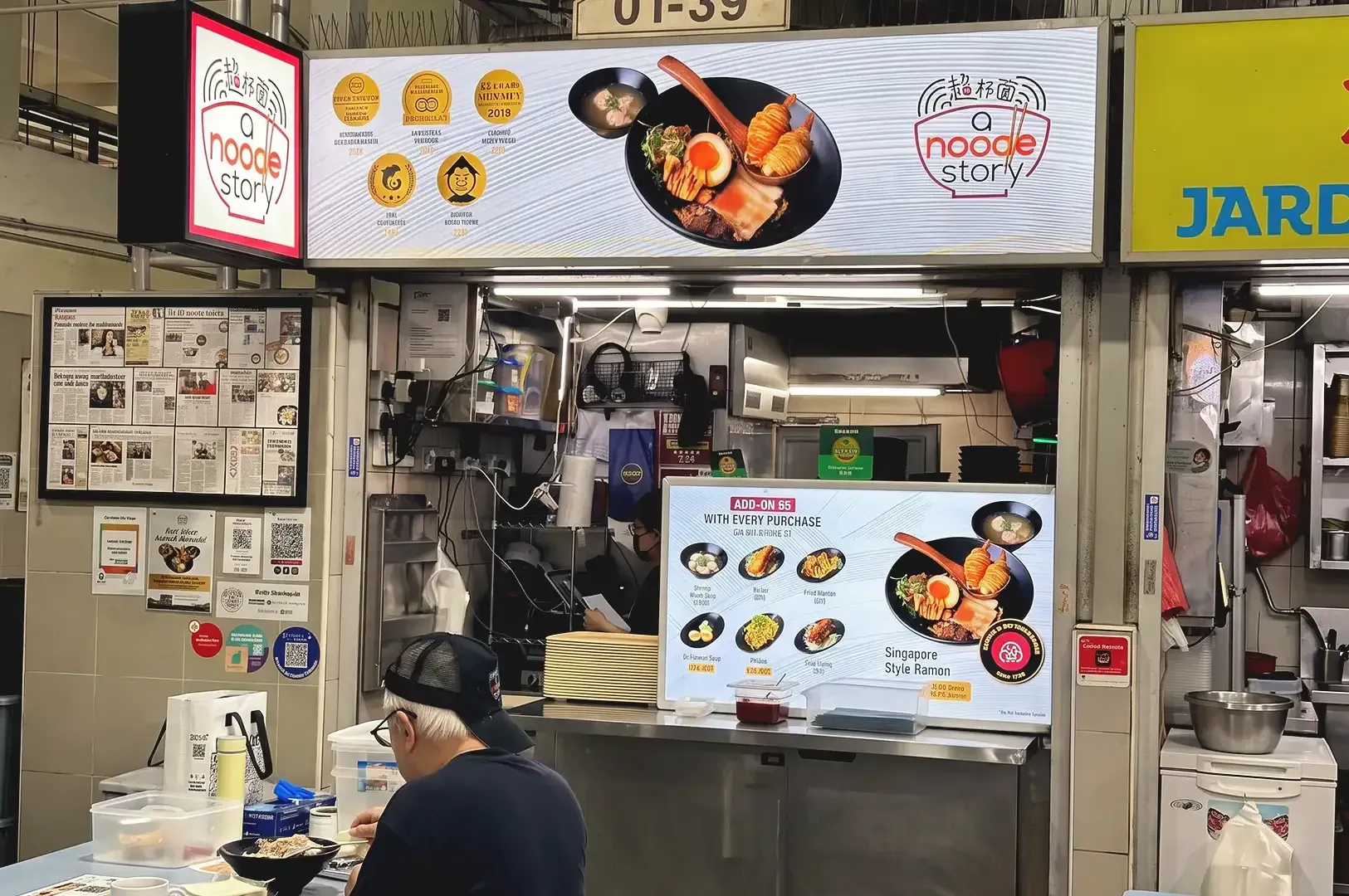 Clean white LED menu display of A Noodle Story's storefront with a man eating in front