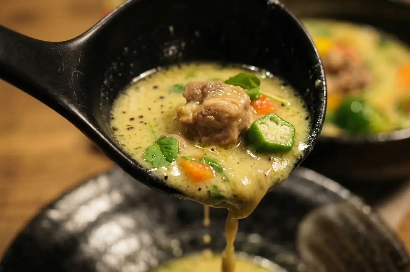 Spoon of soup curry with meat and okra