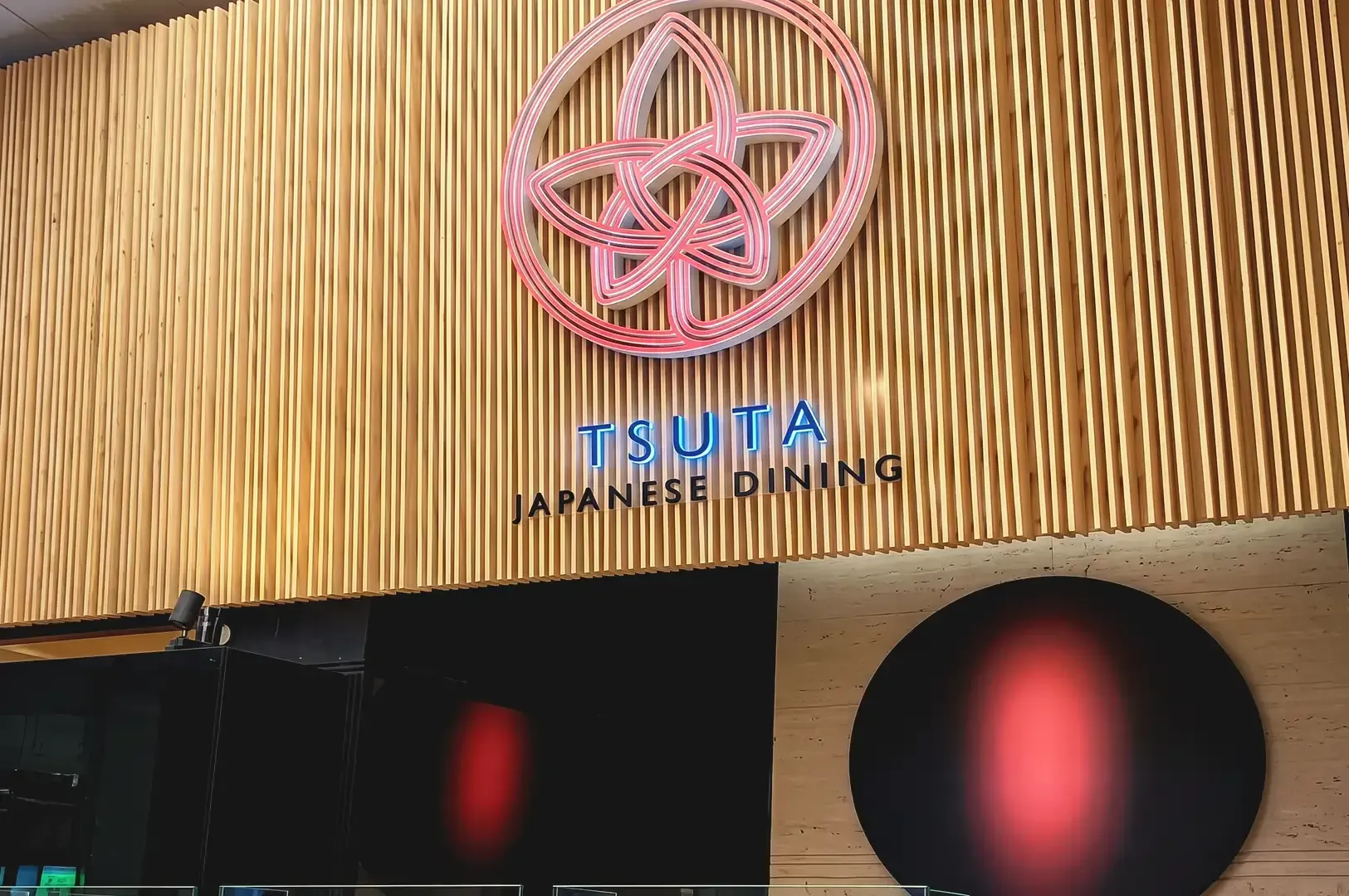 Red Tsuta Japanese Dining logo on wooden material wall pattern