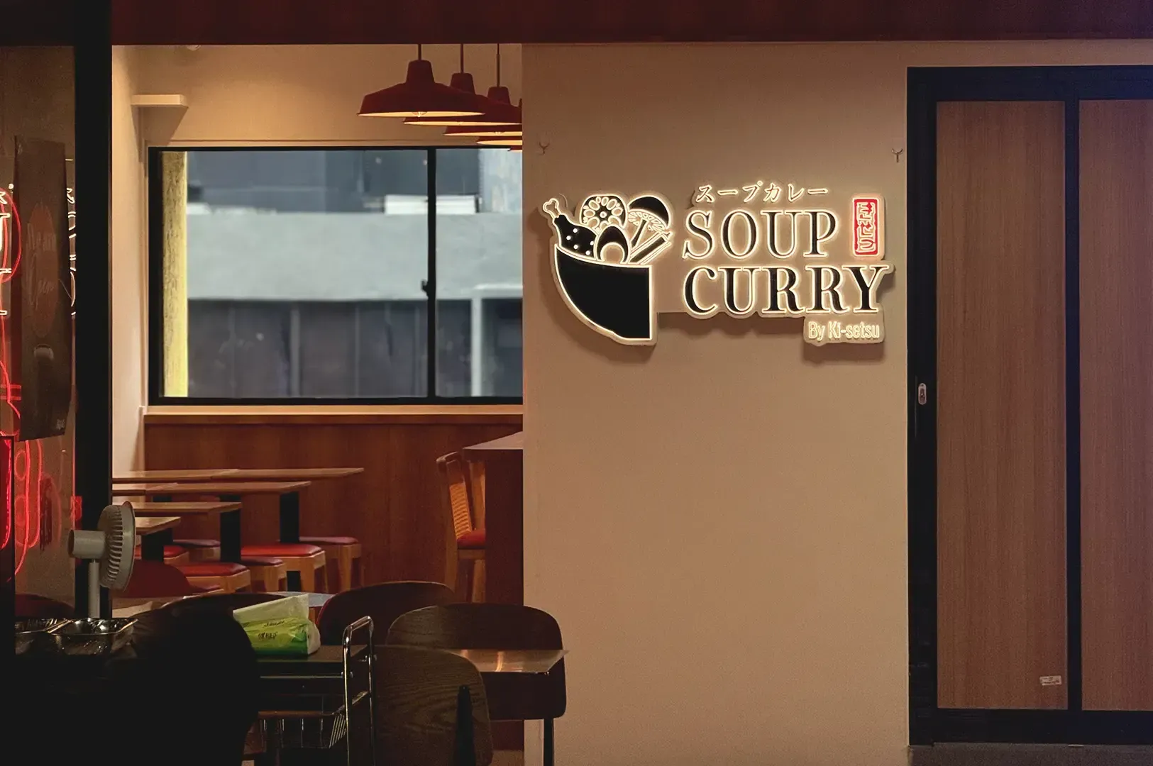 Warm ambient interior of Soup Curry by Ki-setsu furnished with wooden chairs and tables