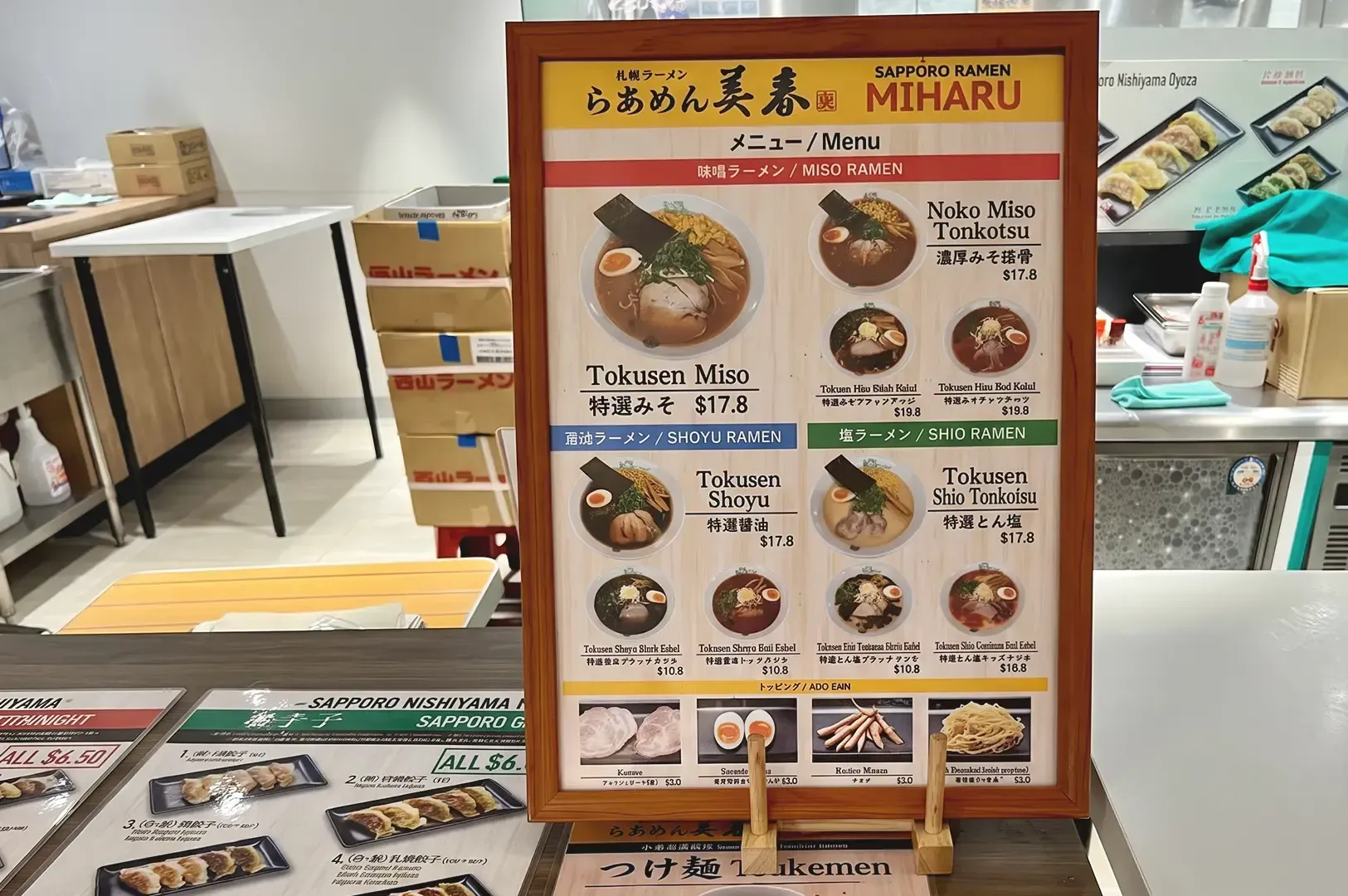 Menu of Sapporo Ramen Miharu pasted on wooden frame displayed on counter