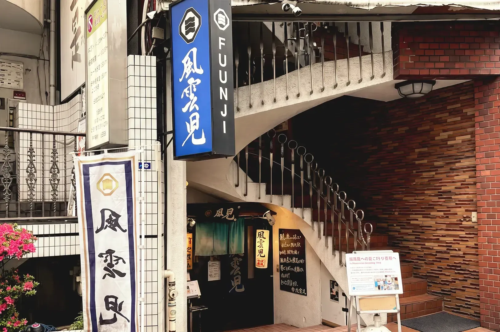 Blue signage with japanese writing and white themed storefront of Fuunji