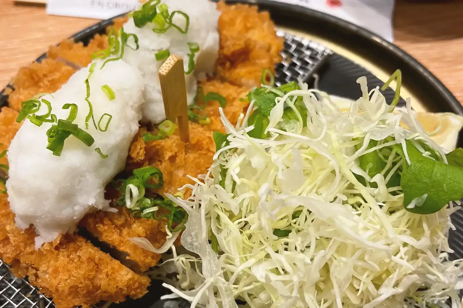 Deep fried pork slices topped with cream with shredded cabbages garnished with spring onions
