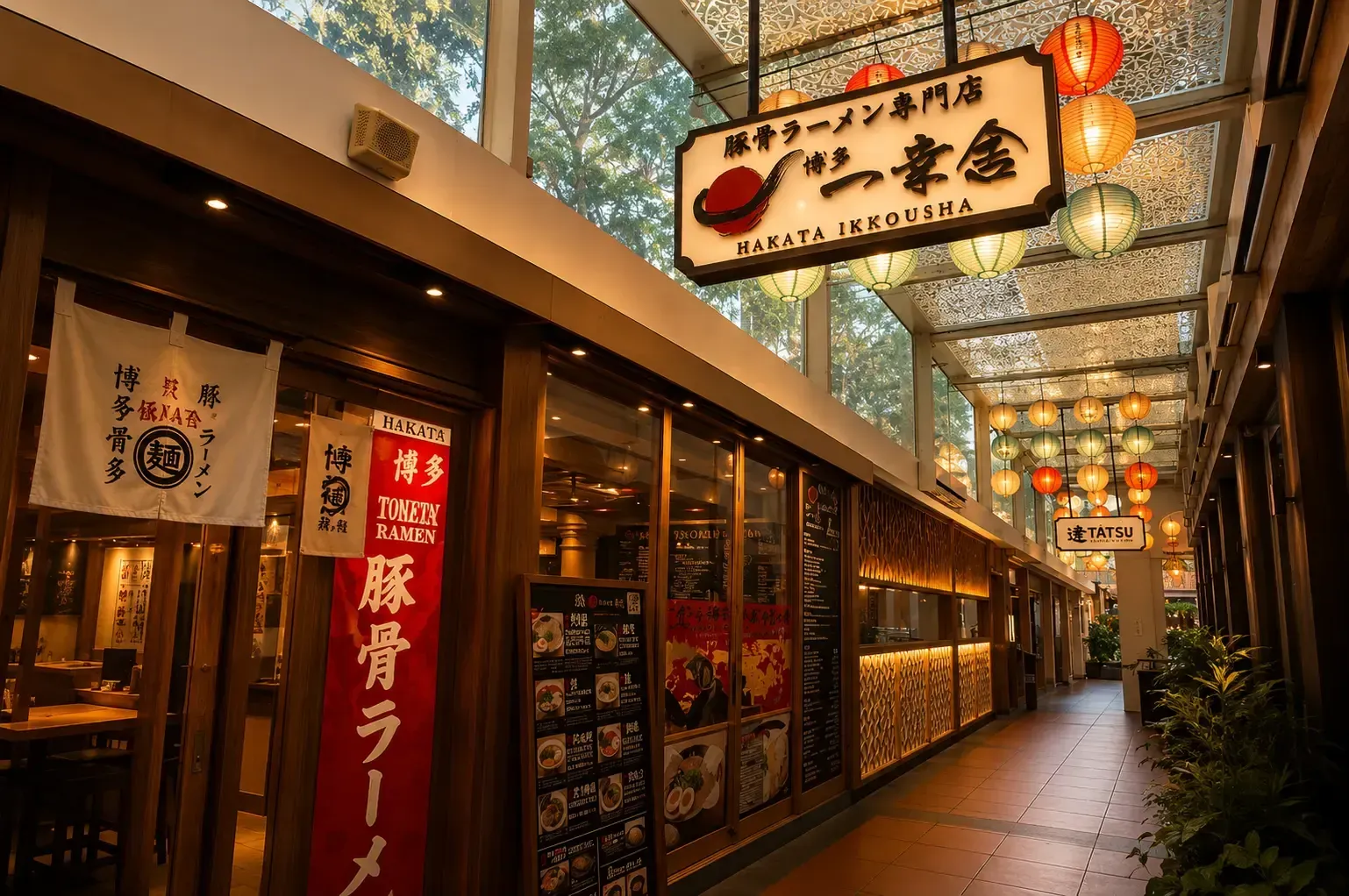Narrow hallway leading past Hakata Ikkousha ramen shop decorated with colorful hanging paper lanterns.