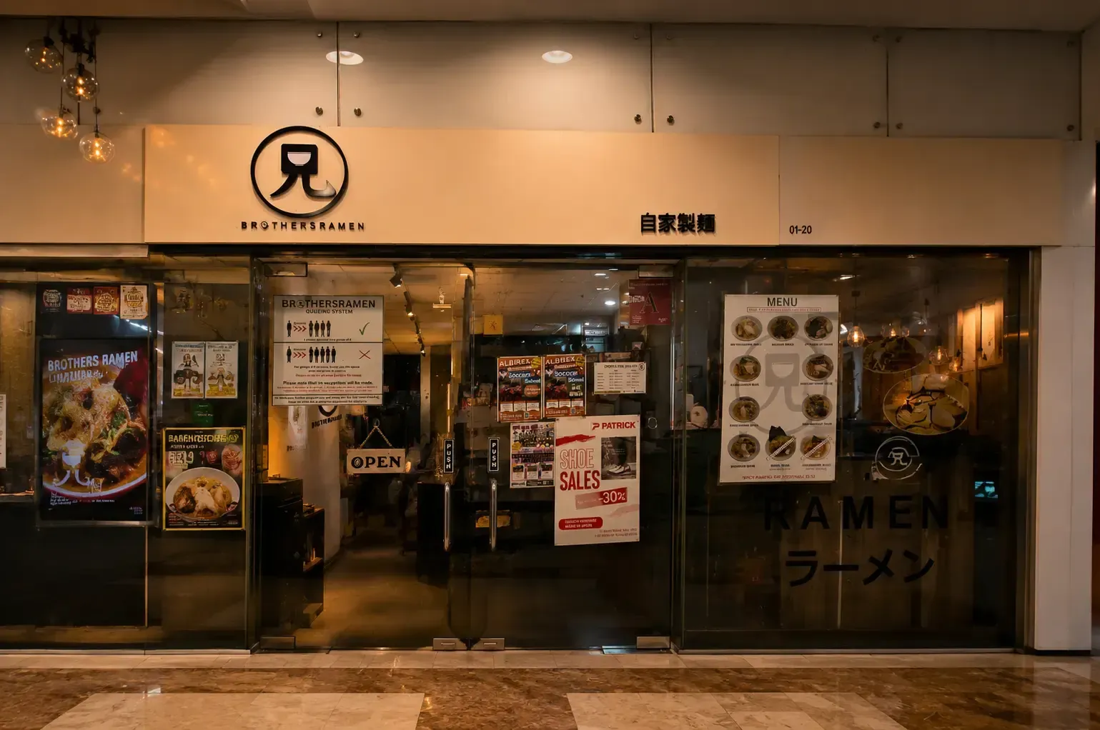 Glass storefront of Brothers Ramen with signage, posters, and a menu board on display.