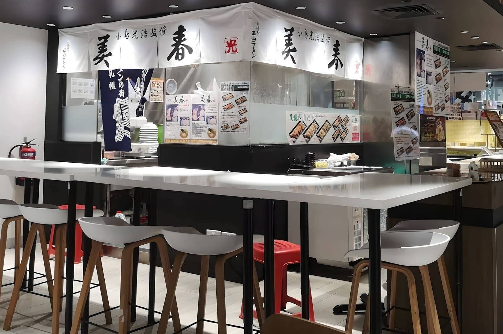 A view of Miharu Ramen restaurant featuring a counter with stools for customers to sit and enjoy their meals.