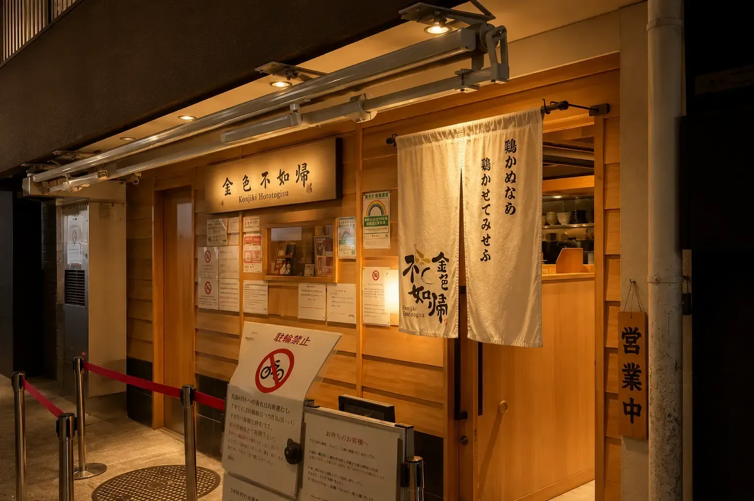 Wooden storefront of Konjiki Hototogisu ramen shop with a white entrance curtain (noren) and Japanese signage.