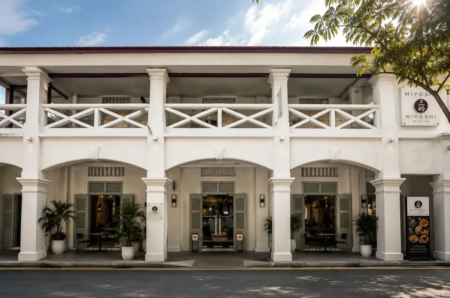 Two-story white colonial-style building housing the Miyoshi by Fat Cow restaurant.