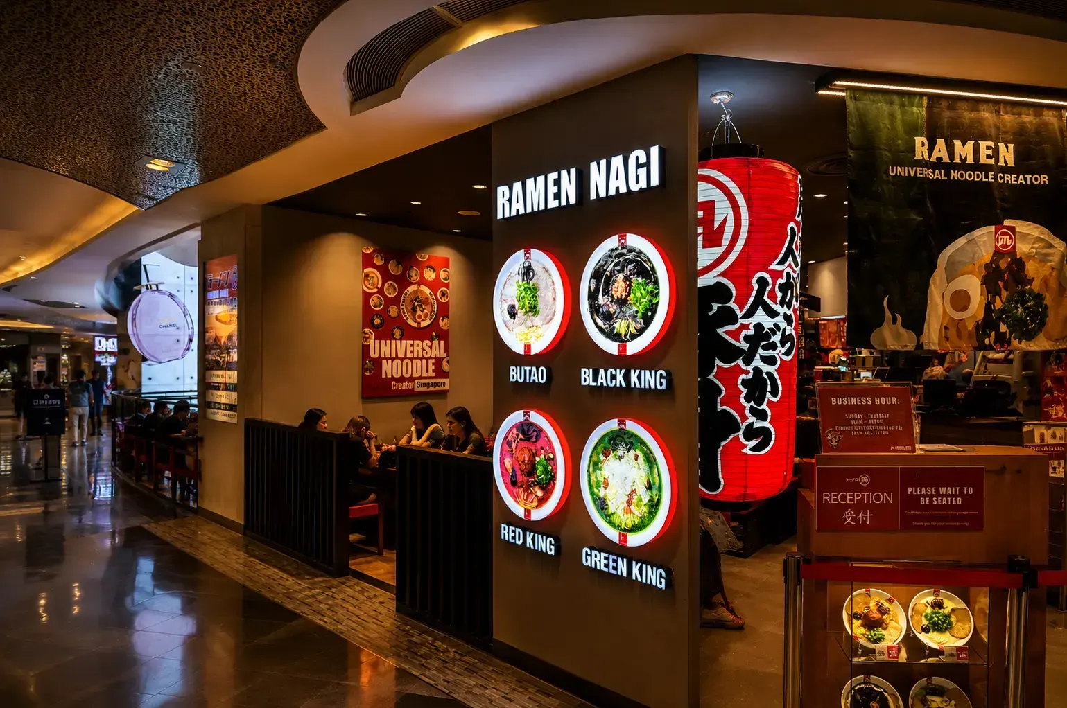 Exterior view of a Ramen Nagi restaurant entrance inside a mall, featuring a large lit wall menu.
