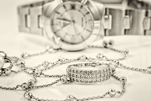 Silver ring and chain on the background of watches - Goshen, IN - Snider's Leading Jewelers, Inc. Silver ring and chain on the background of watches - Goshen, IN - Snider's Leading Jewelers, Inc.