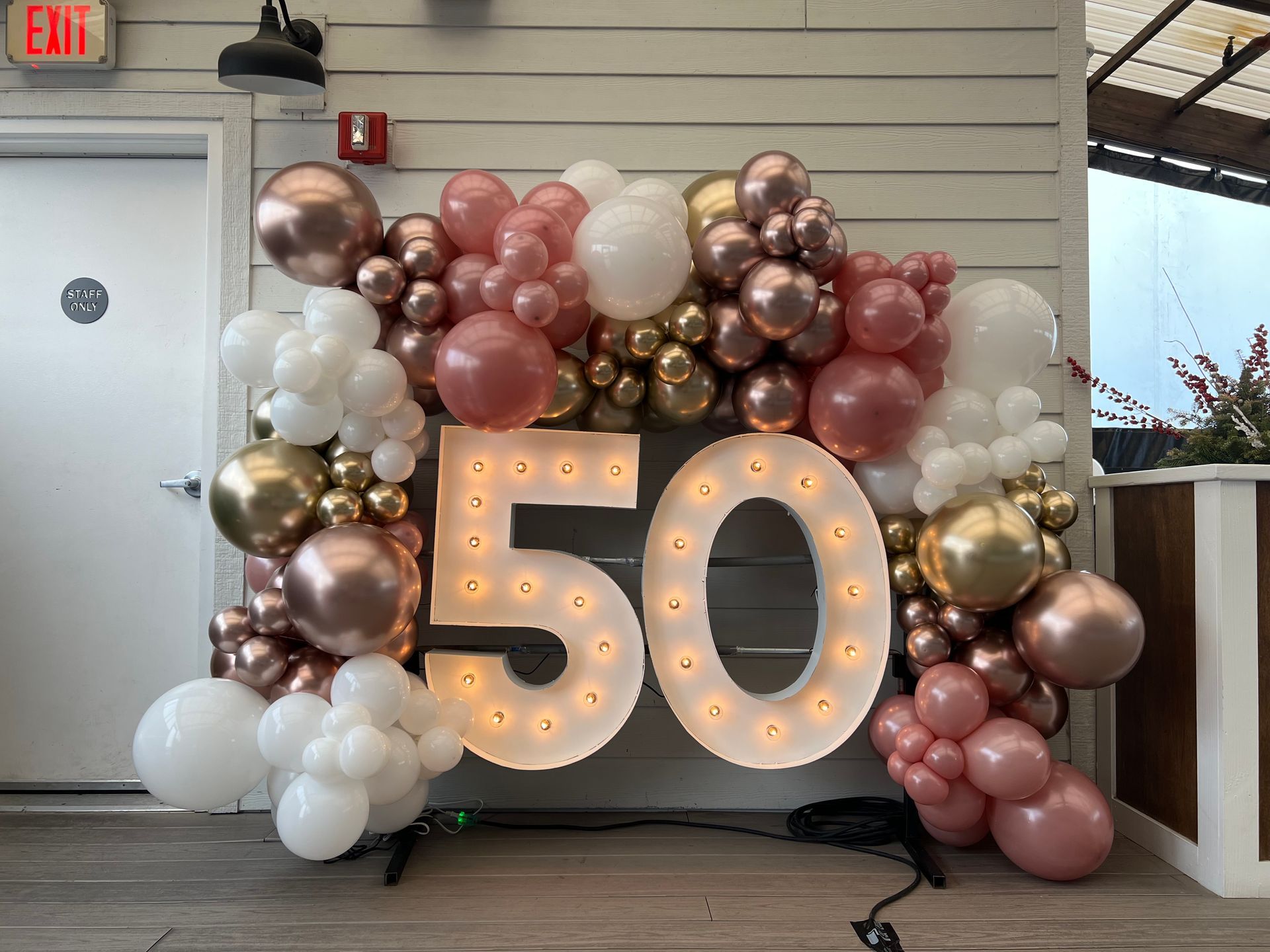The number 50 is surrounded by balloons and lights.