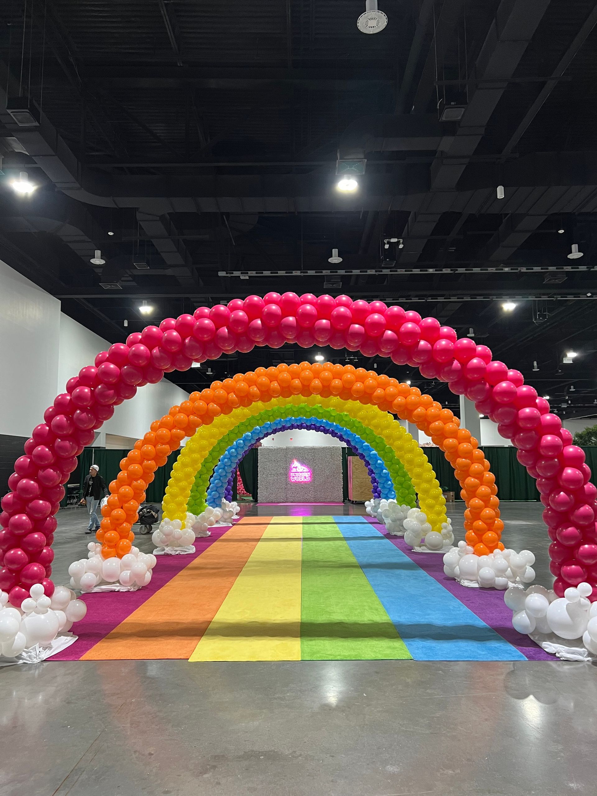 There is a rainbow made of balloons in the middle of a room.
