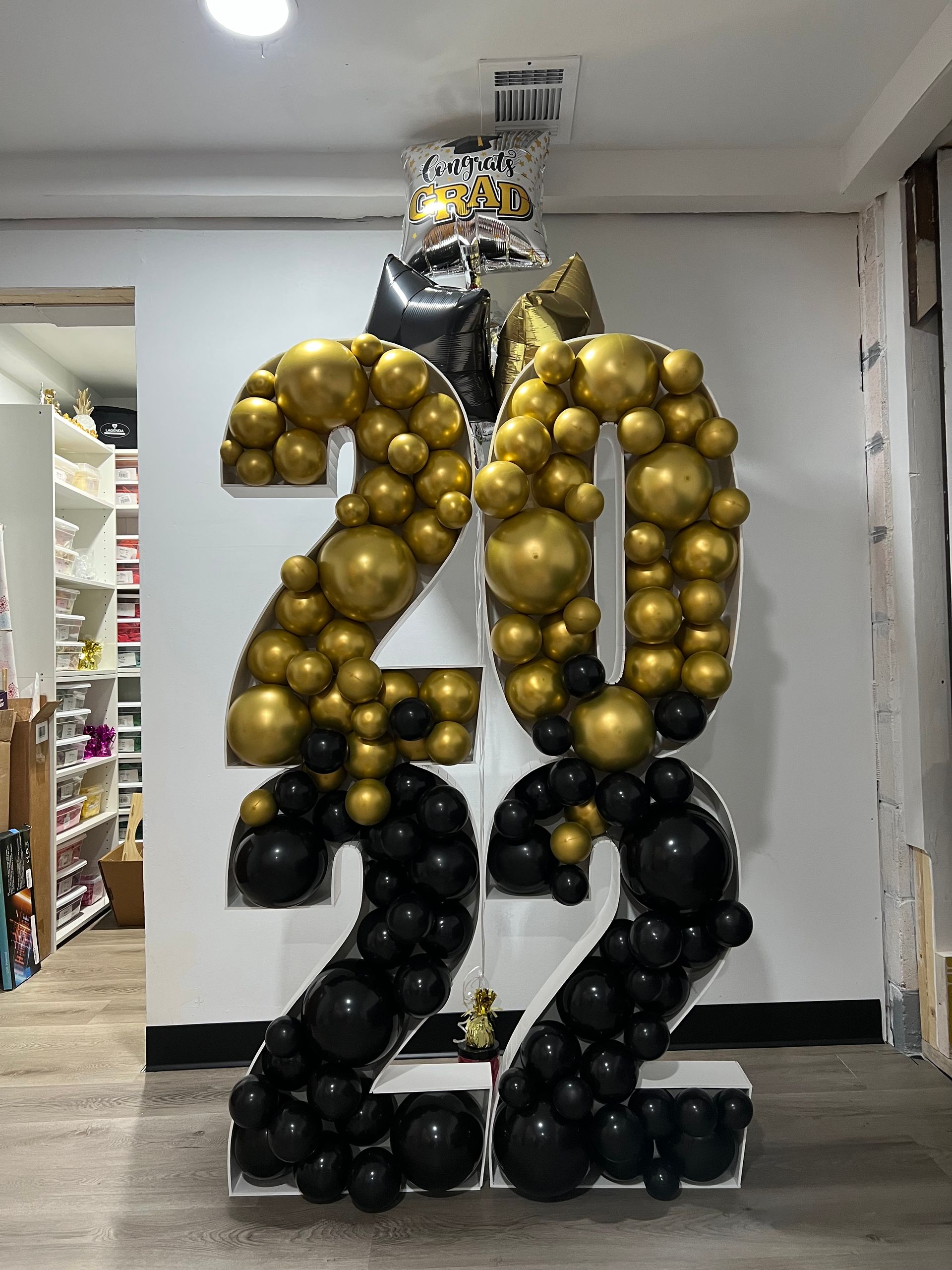 The number 20 is made of balloons in a room.