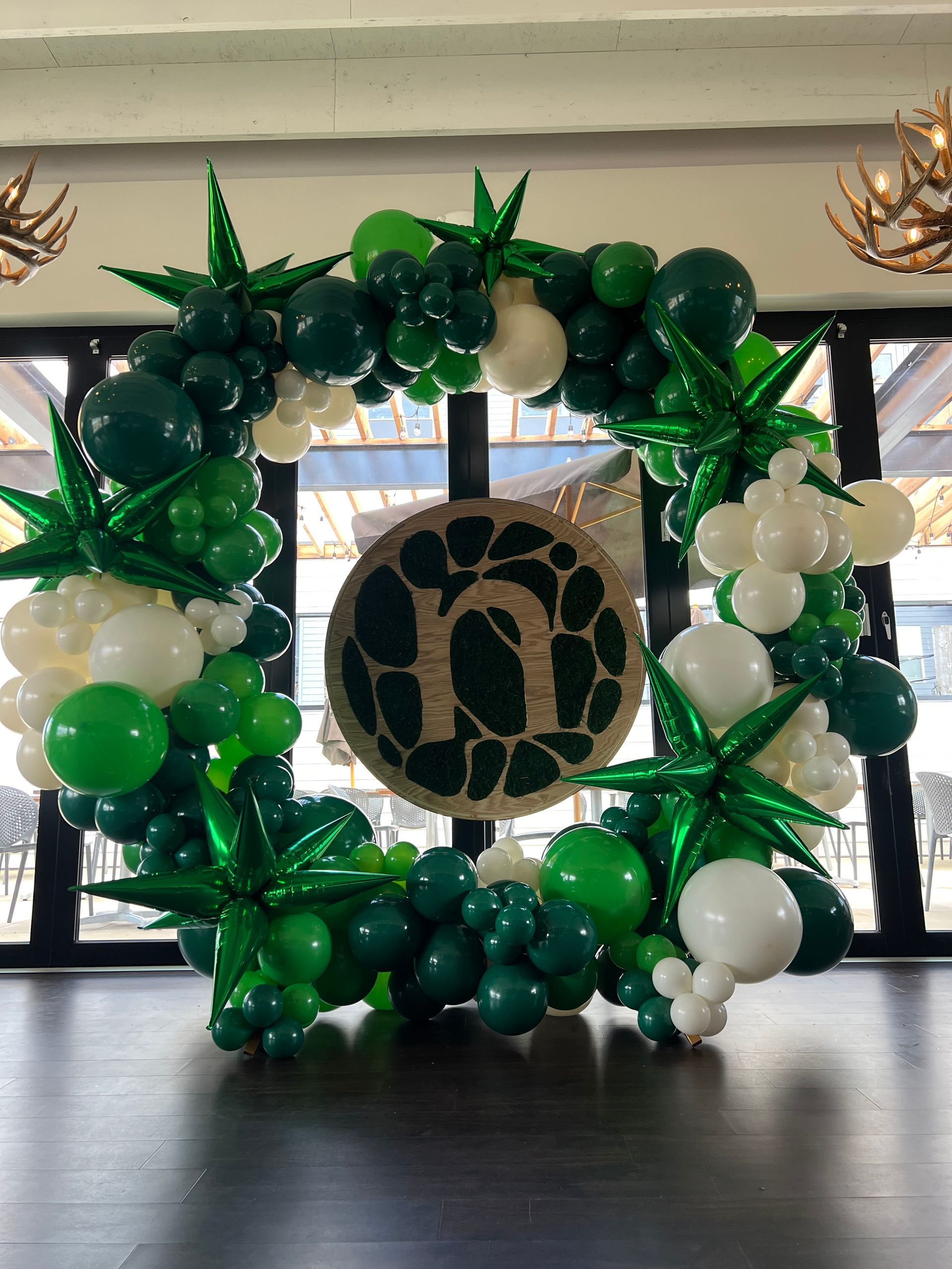 A wreath of green and white balloons with a letter n in the middle.