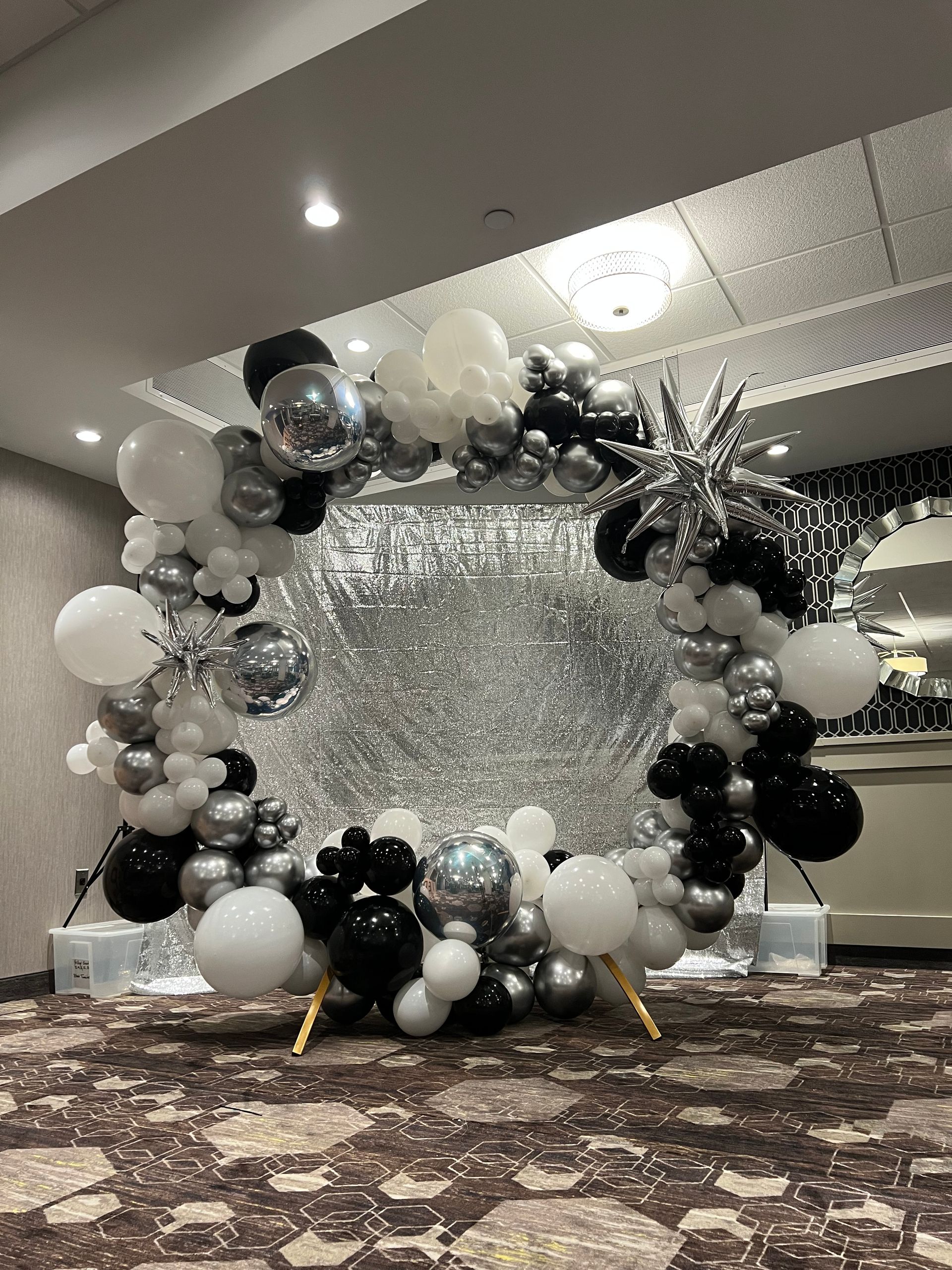 A circle of balloons is sitting on the floor in a room.