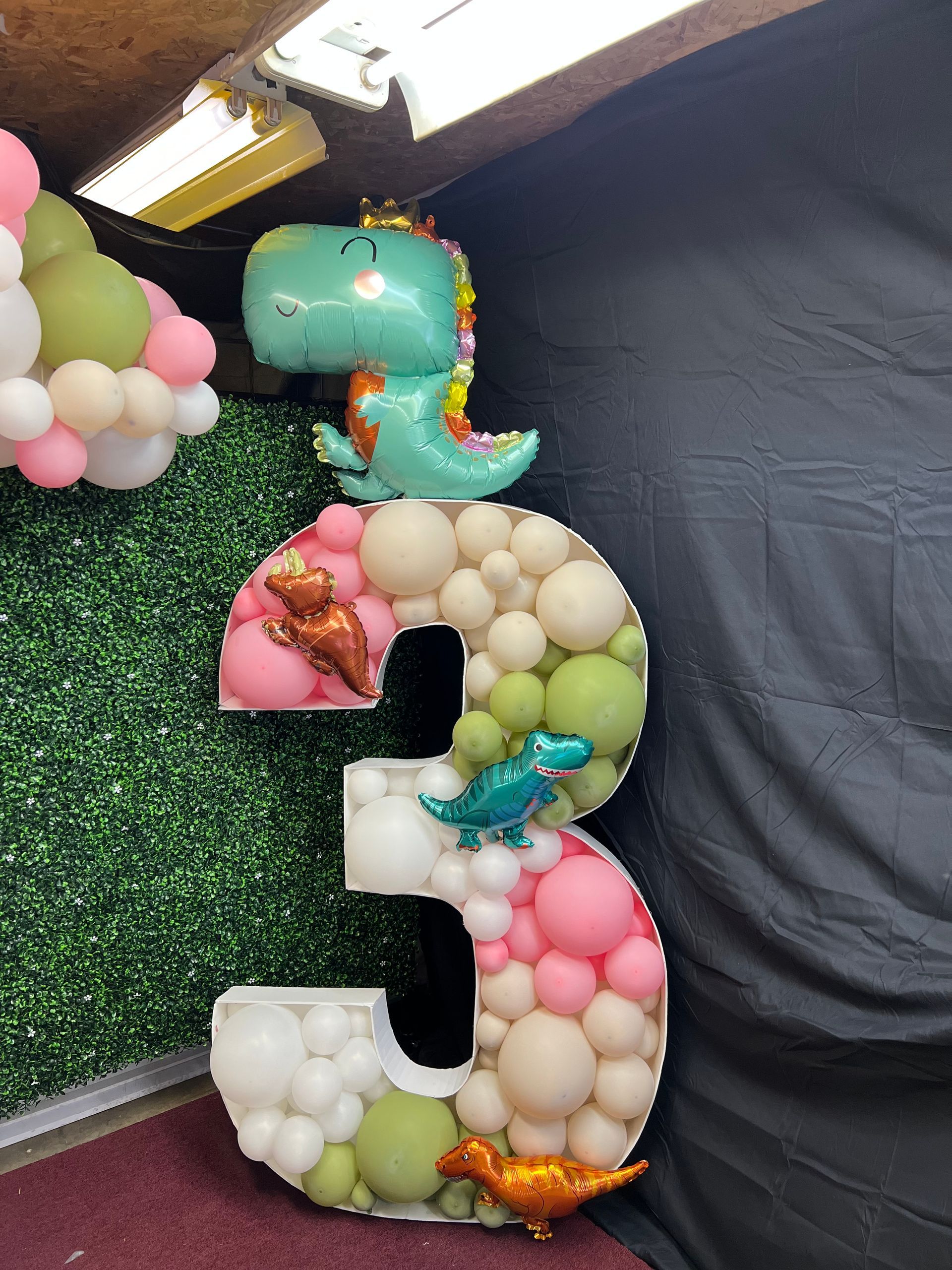 The number three is made of balloons and dinosaurs.
