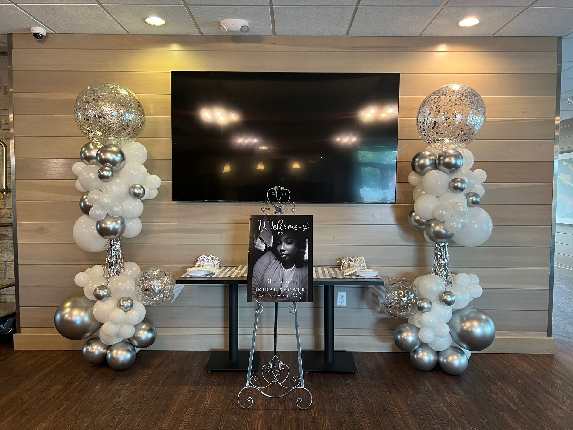 A room with balloons and a picture of a man on a table.