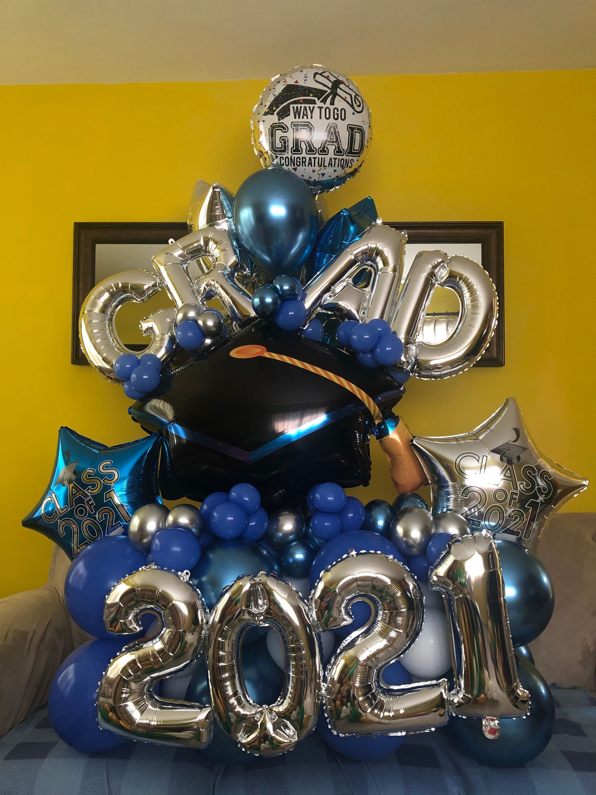 A bunch of blue and silver balloons with the year 2021 on them