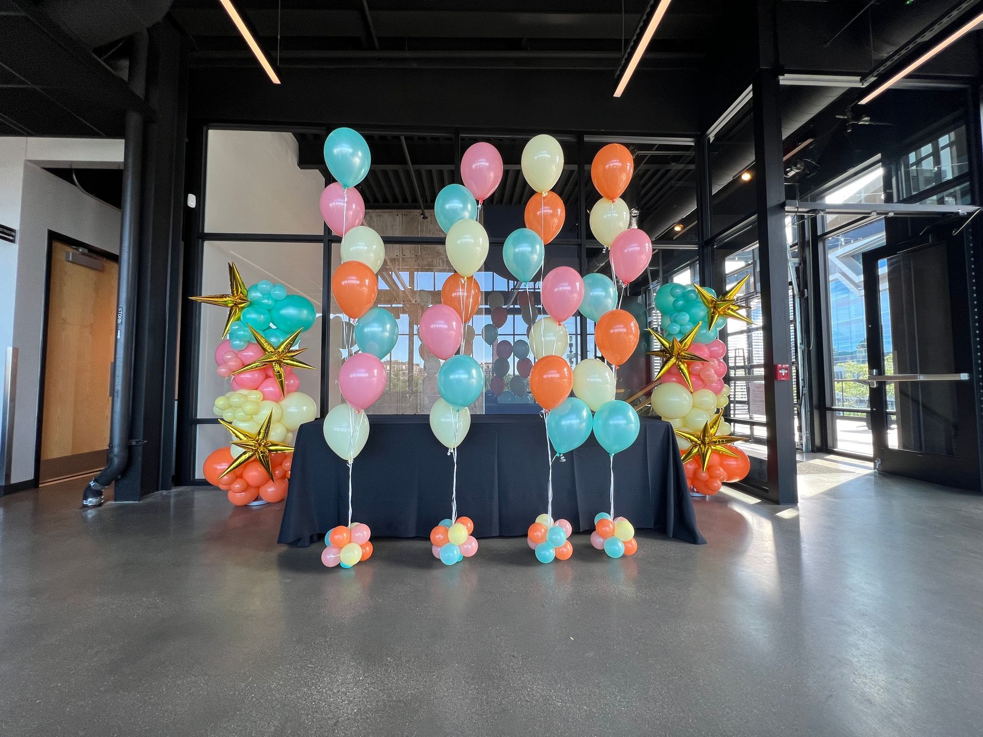 A bunch of balloons are sitting on a table in a room.