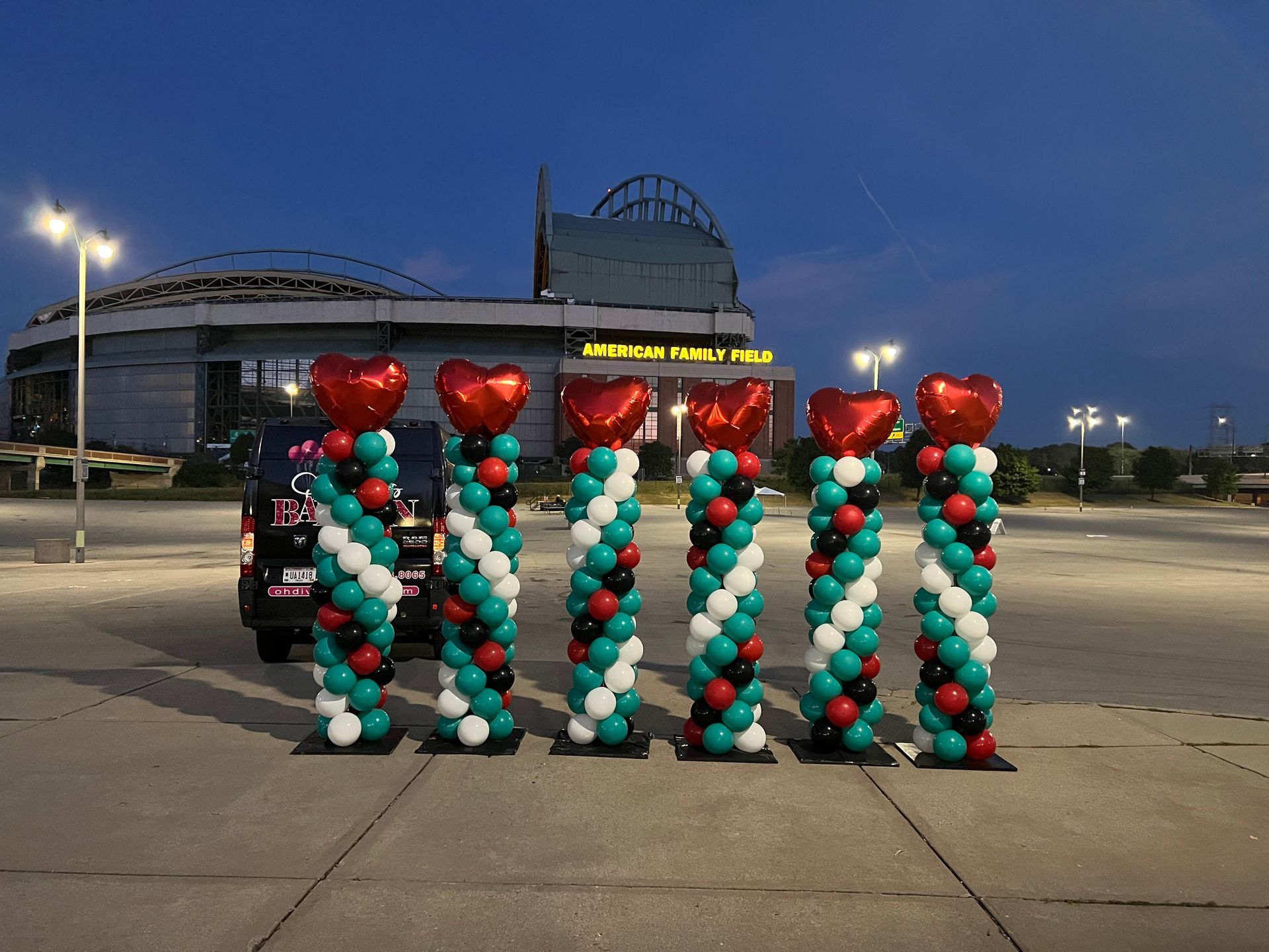 A row of balloon columns with hearts on them in front of a building