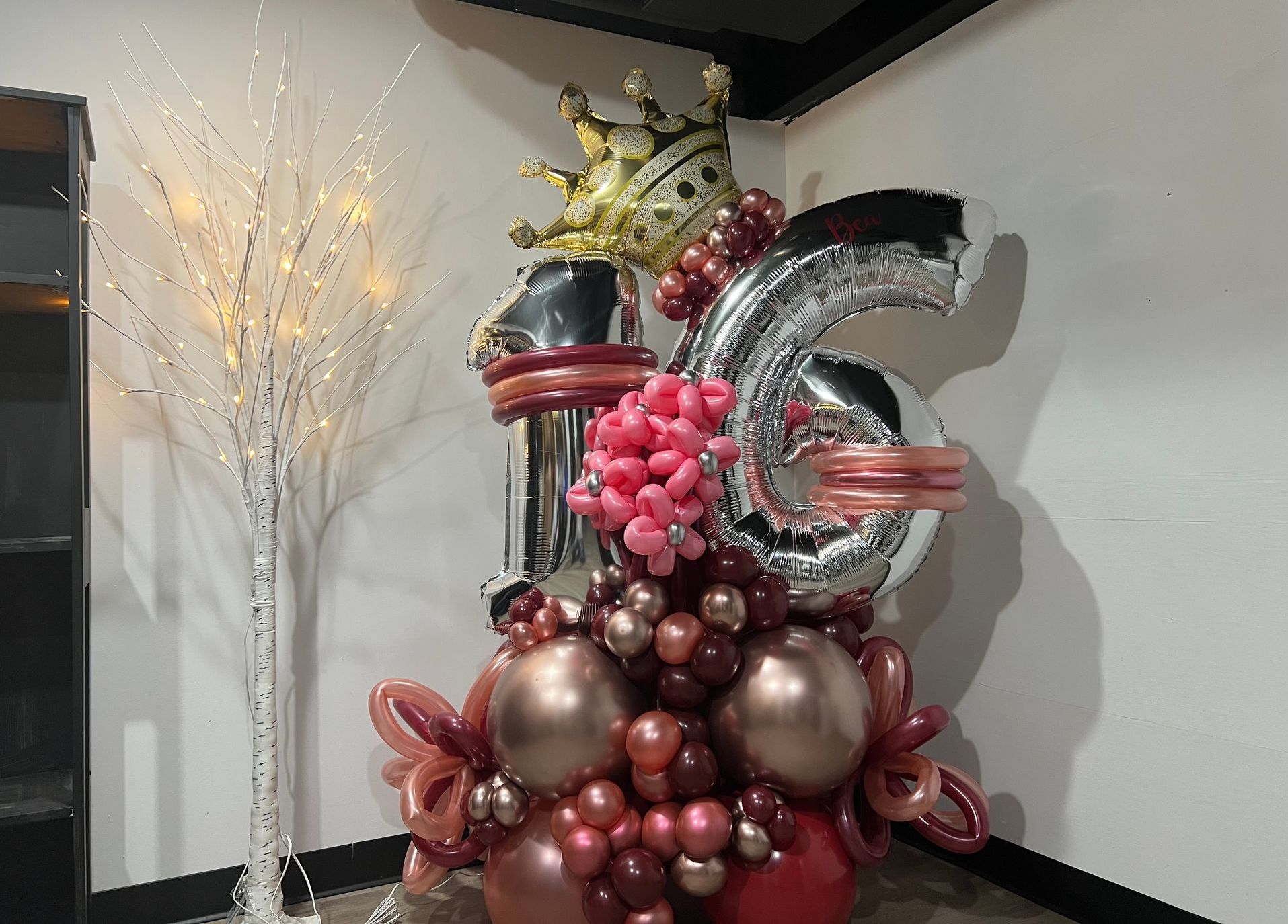 A bunch of balloons are sitting on a table in a room.