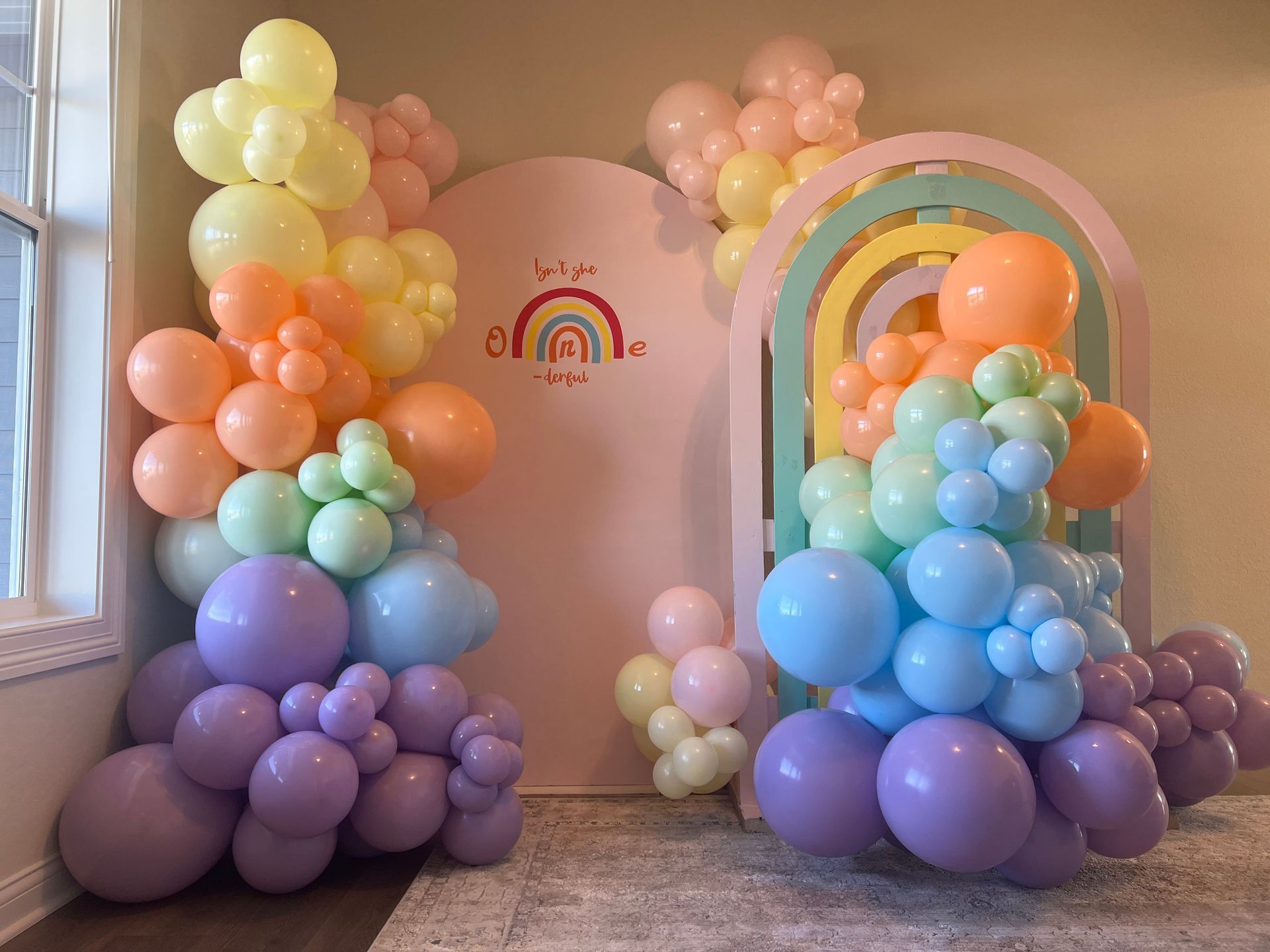 A room filled with lots of colorful balloons and a rainbow.