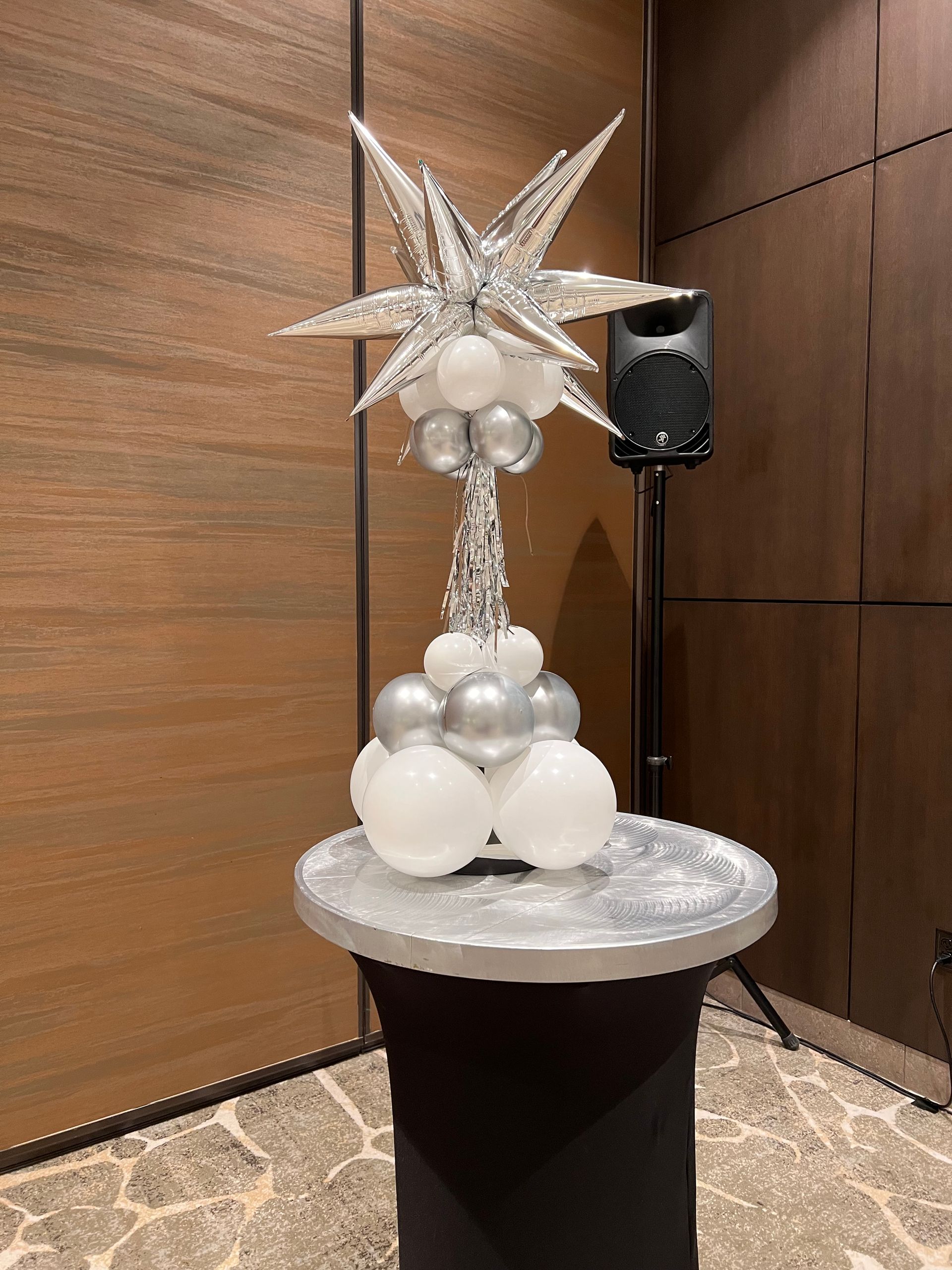 A balloon arrangement is sitting on top of a table in a room.