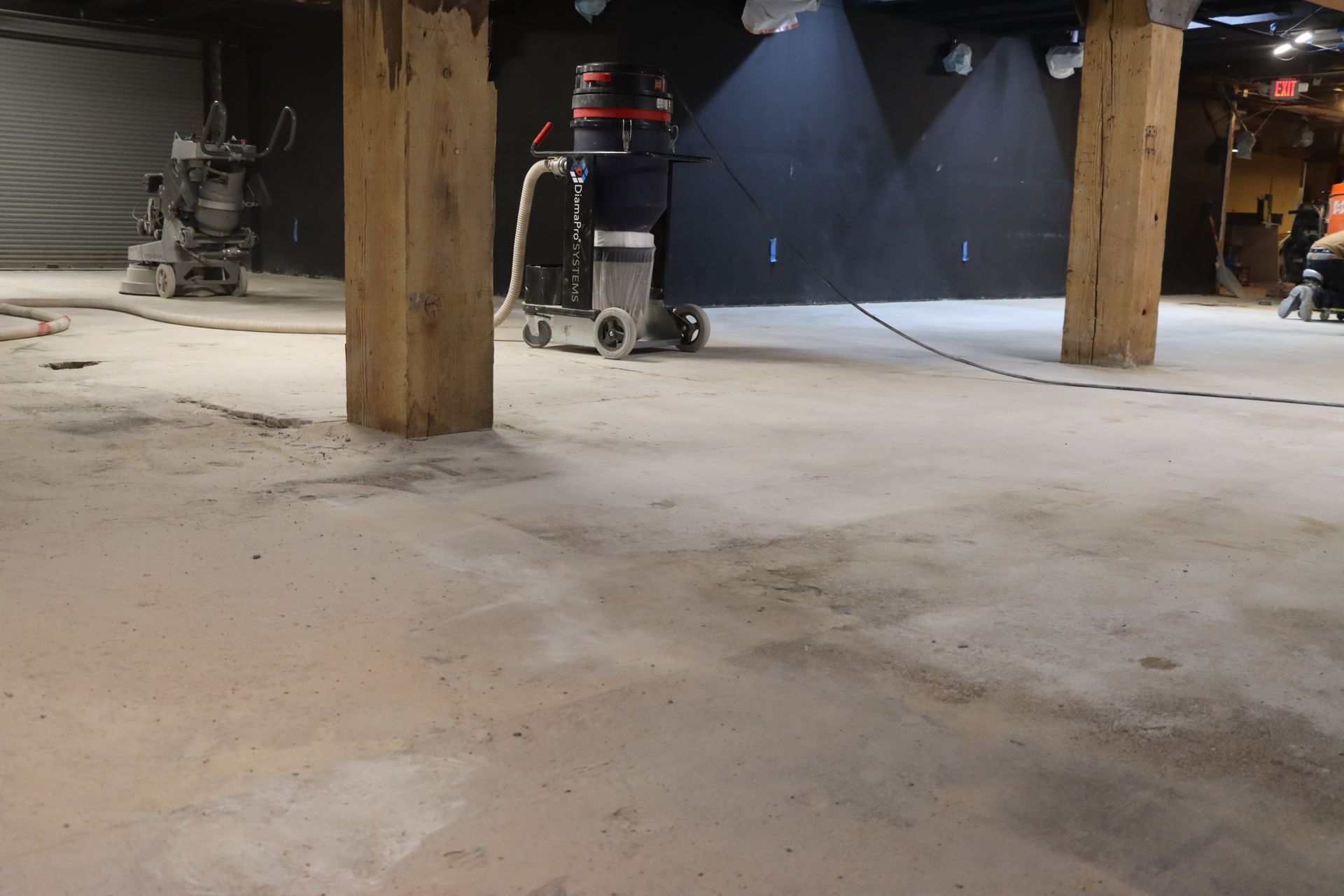 A vacuum cleaner is being used to clean a concrete floor.