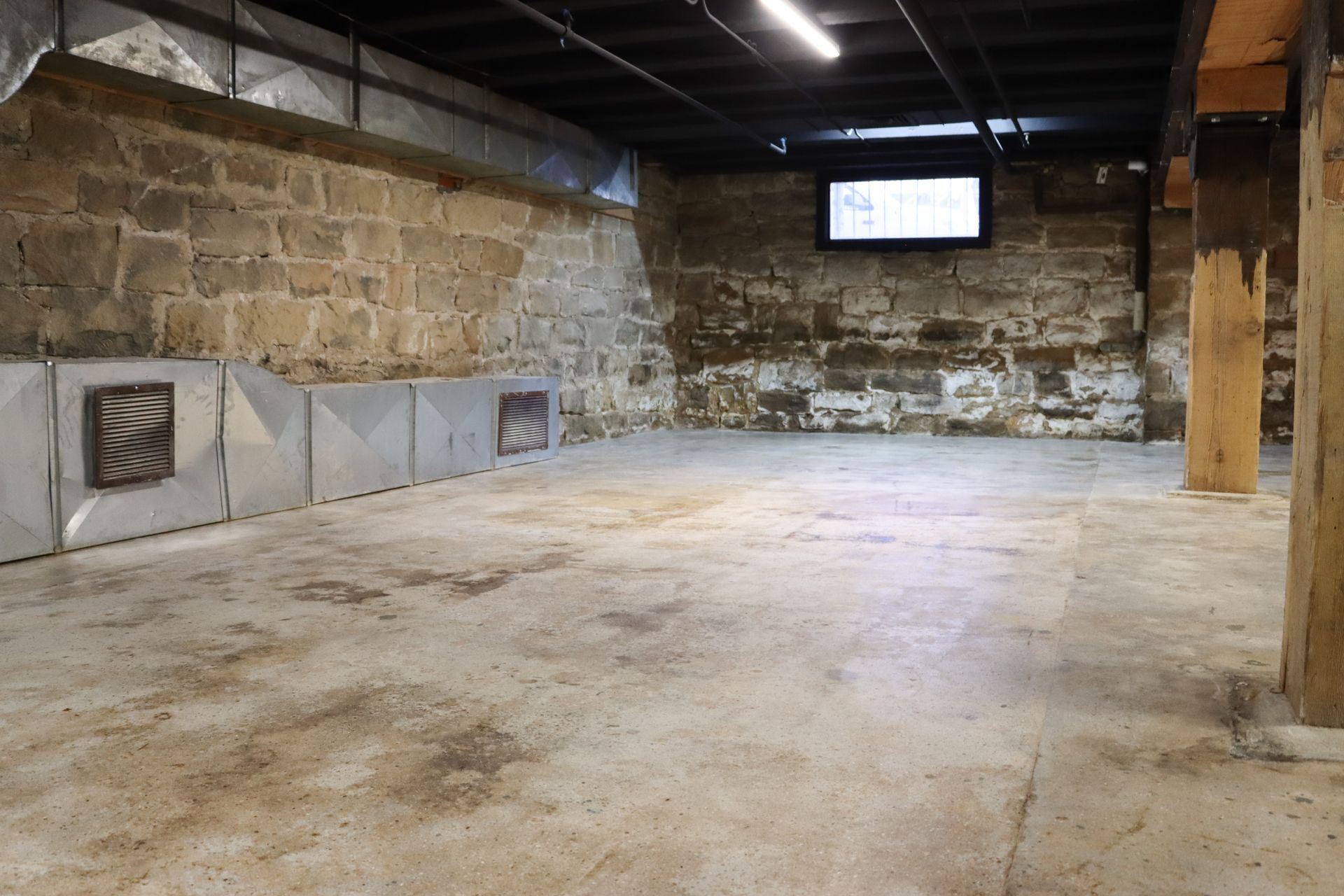 An empty basement with a television on the wall.