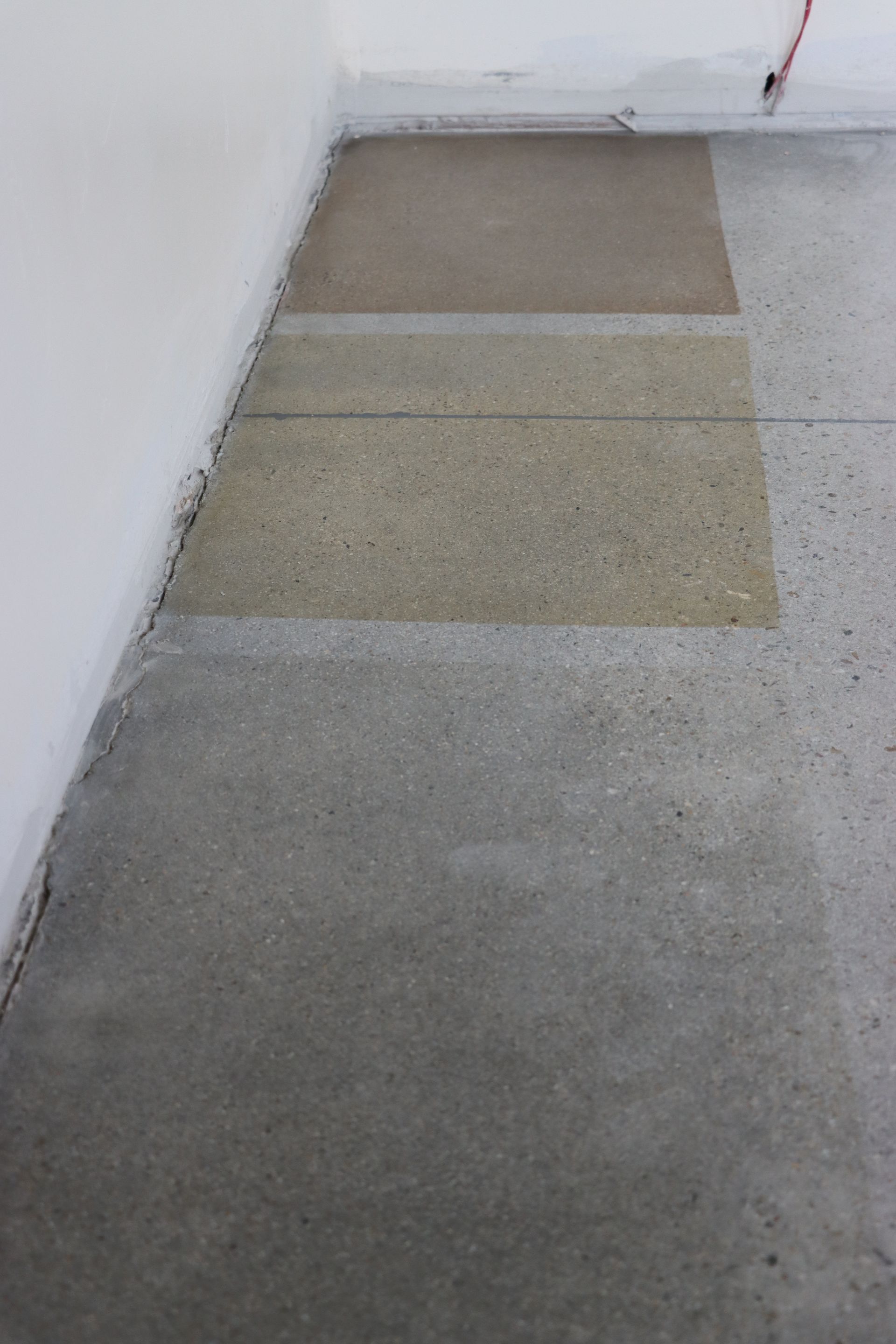 A close up of a concrete floor in a room with a broom.