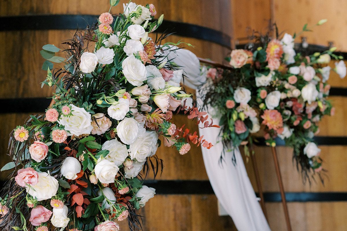 A modern arch decorated with autumn flowers for a wedding ceremony in a brewery.