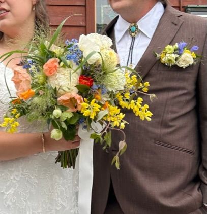 A bright wildflower bridal bouquet and groom's pocket boutonniere