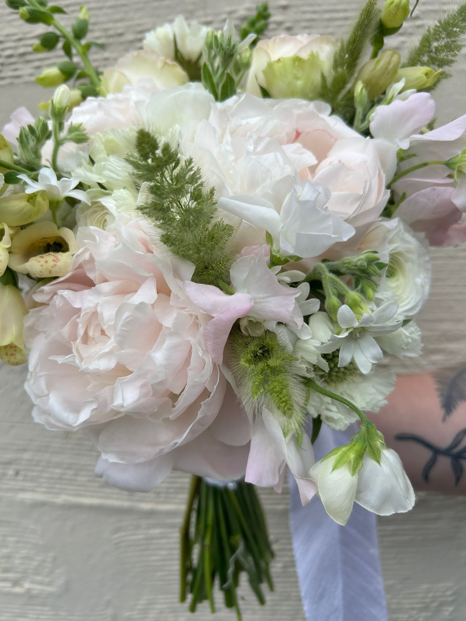 A spring bridal bouquet with peonies and sweet peas