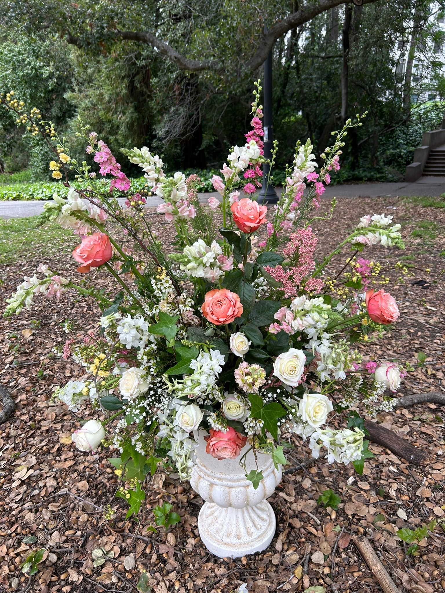 Wedding ceremony urn overflowing with pink and white flowers