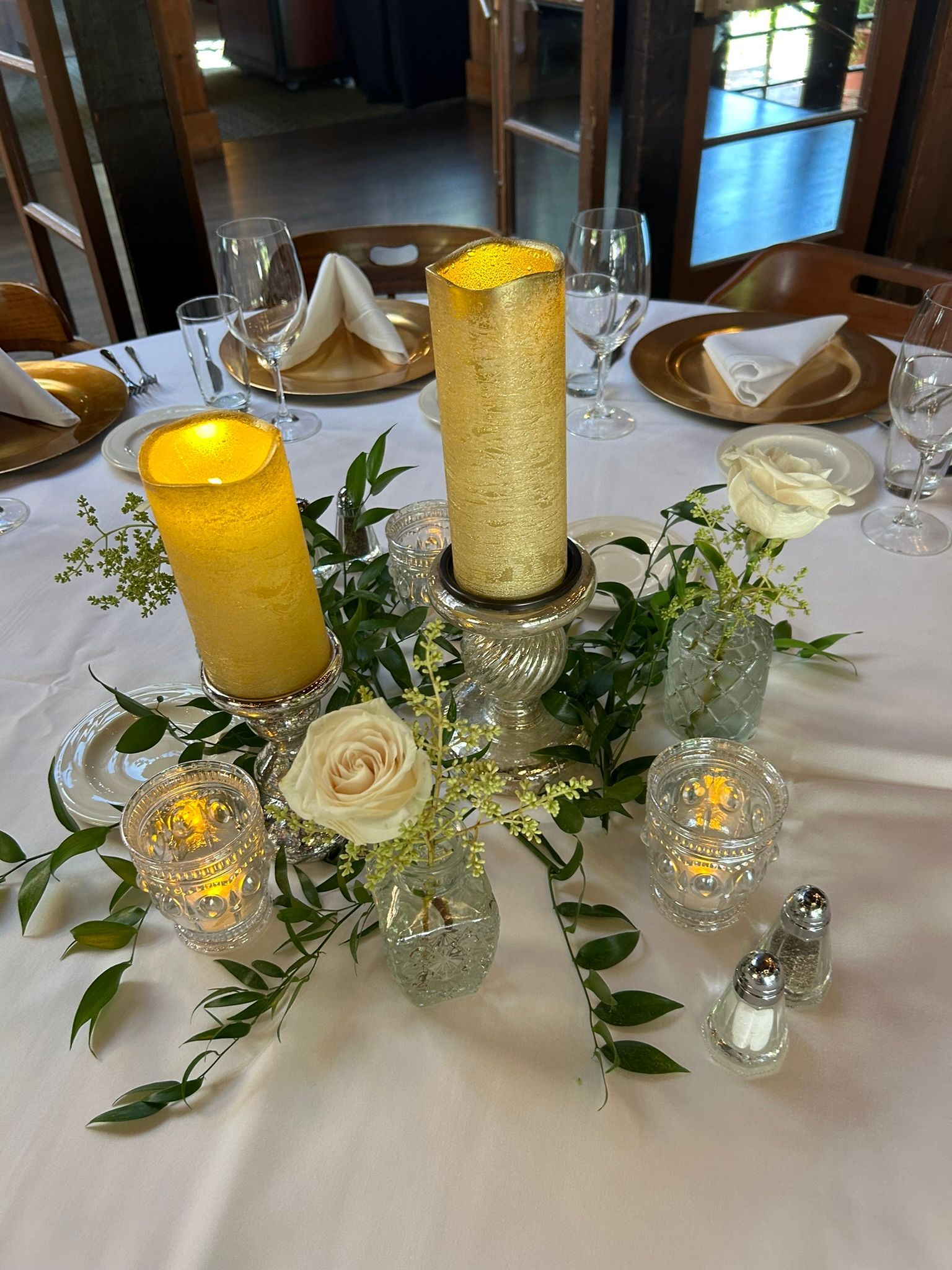 A table with a candle and flowers on it.