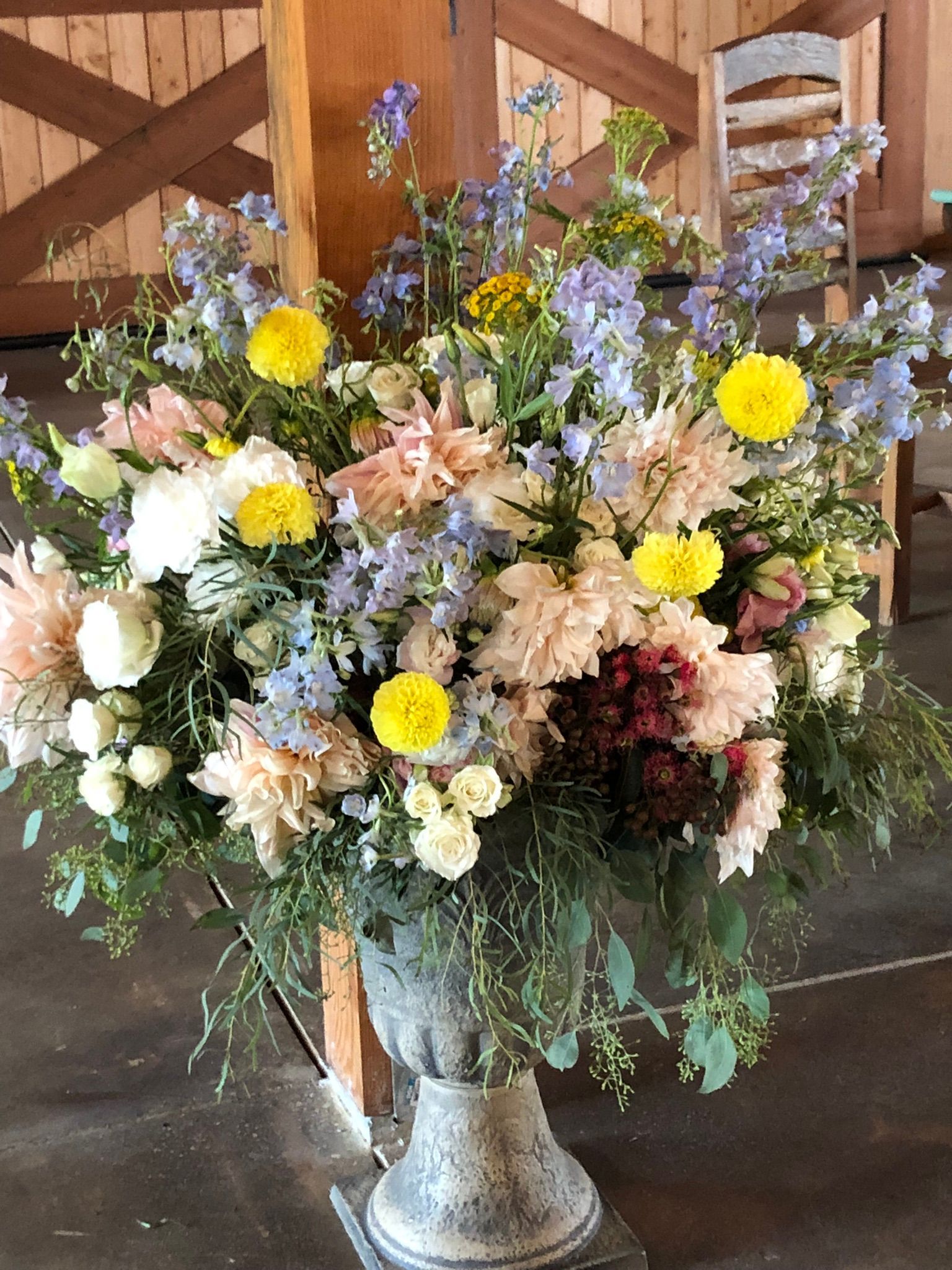 A large vase filled with flowers is sitting on a table.