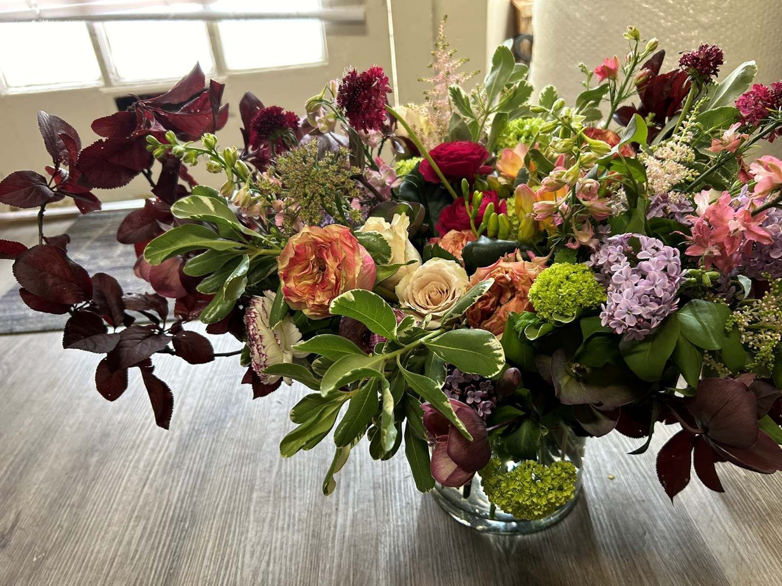 An elegant flower design with spring flowers and branches in a vase