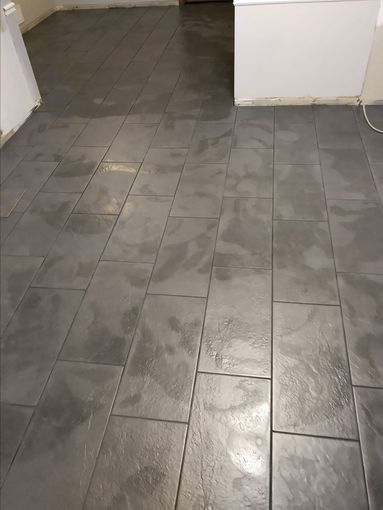Dark gray rectangular tiles cover a floor.