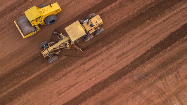 An Aerial View Of Two Yellow Tractors Working On A Dirt Road — Arnway Pty Ltd In Kempsey, NSW