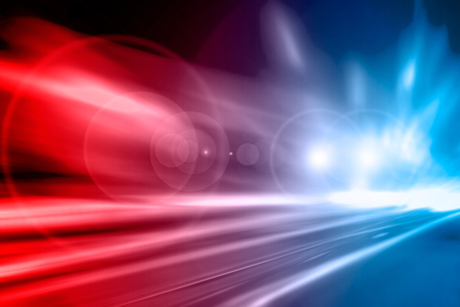 A red , white and blue light is shining on a dark background.