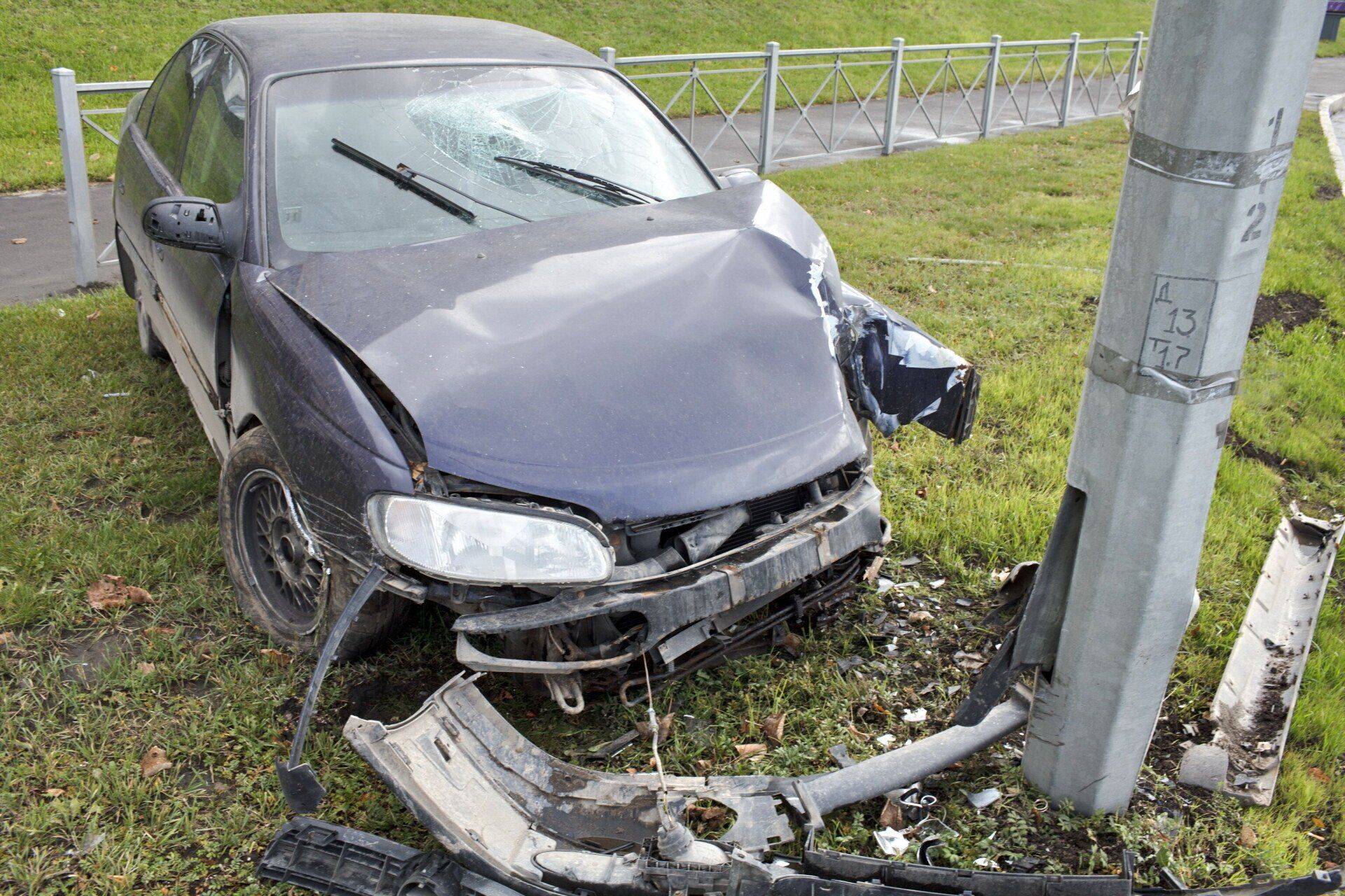 A car that has crashed into a pole in the grass