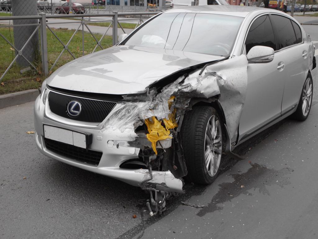 A silver lexus car with a damaged front end